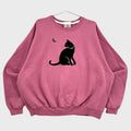 Pink sweatshirt with a black cat and butterfly design on a gray background
