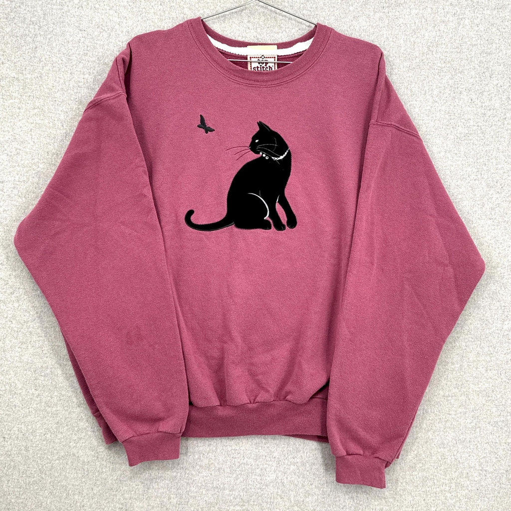 Pink sweatshirt with a black cat graphic on a light gray background