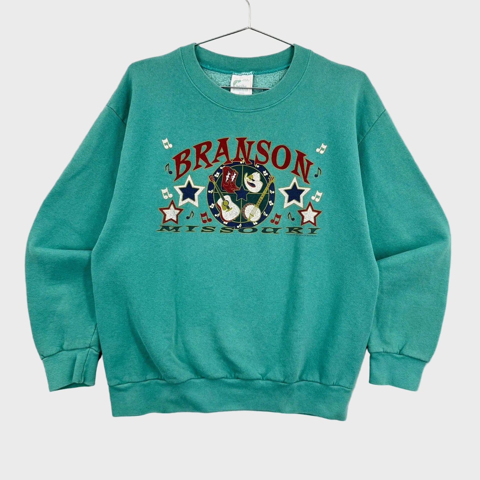 Teal sweatshirt with 'Branson, Missouri' graphic on a gray background