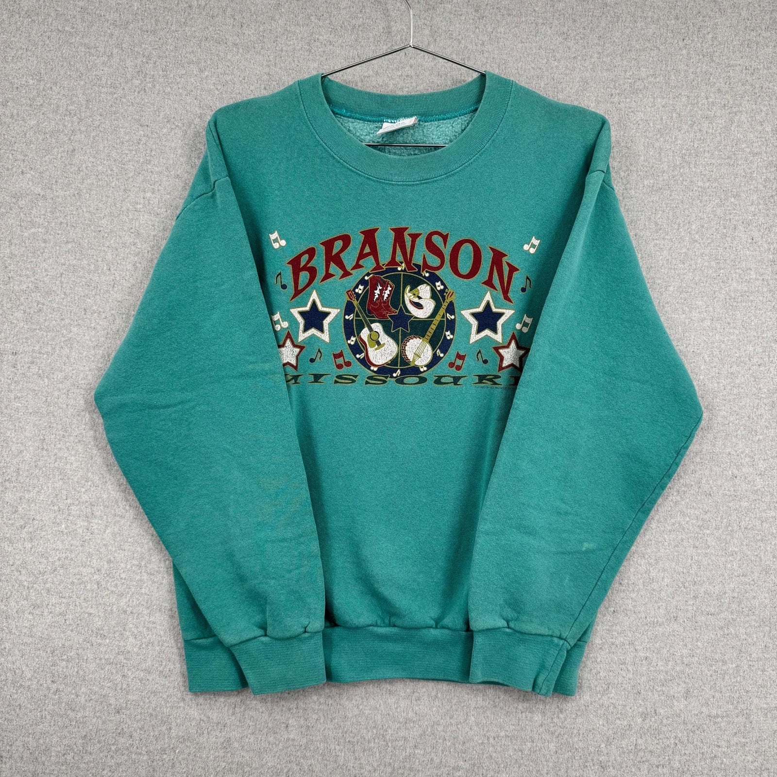 Teal sweatshirt with 'Branson, Missouri' graphic on a gray background