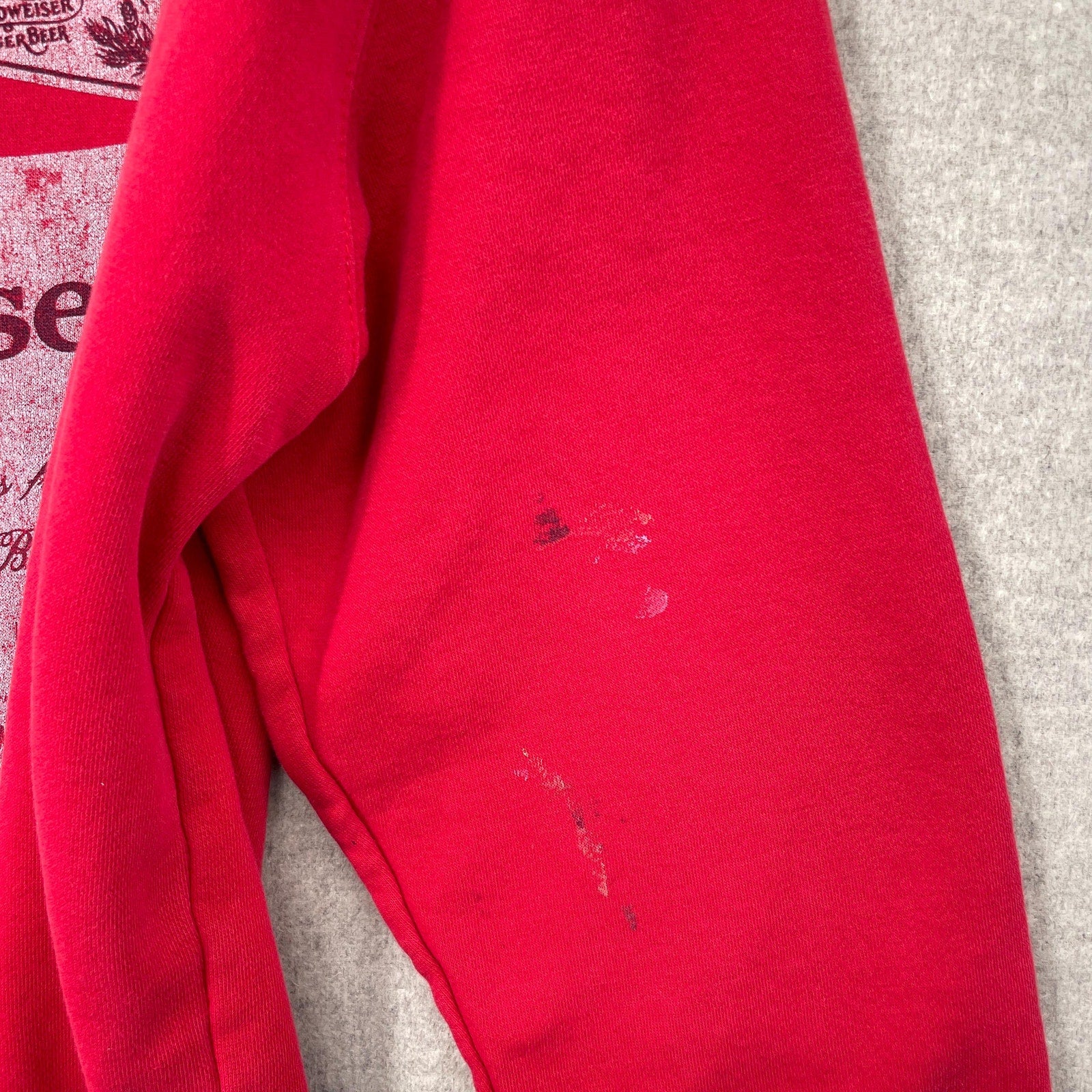 Red fabric with visible stains on a gray surface