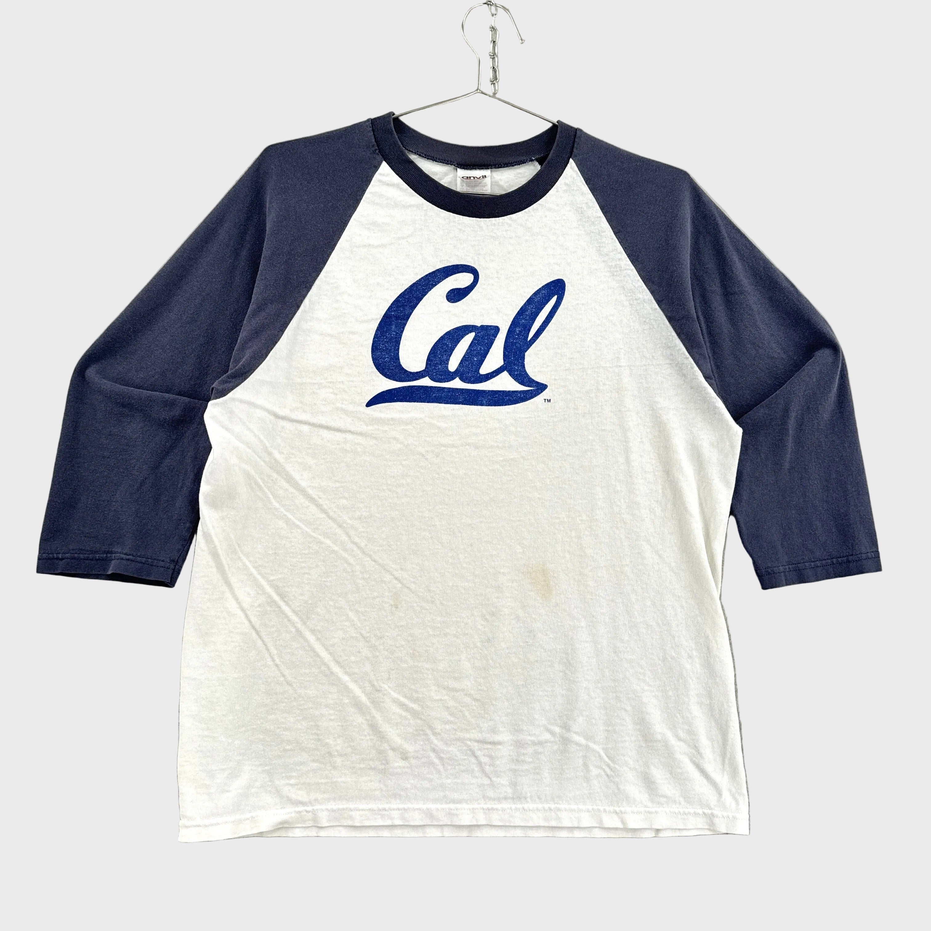 White and navy baseball shirt with 'Cal' logo on a gray background