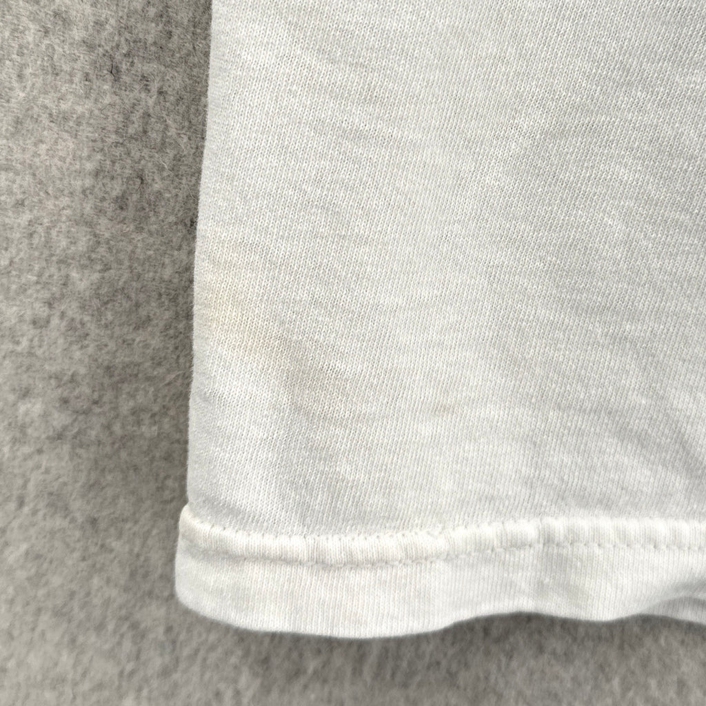 Close-up of a white fabric edge with a gray background, stain spots