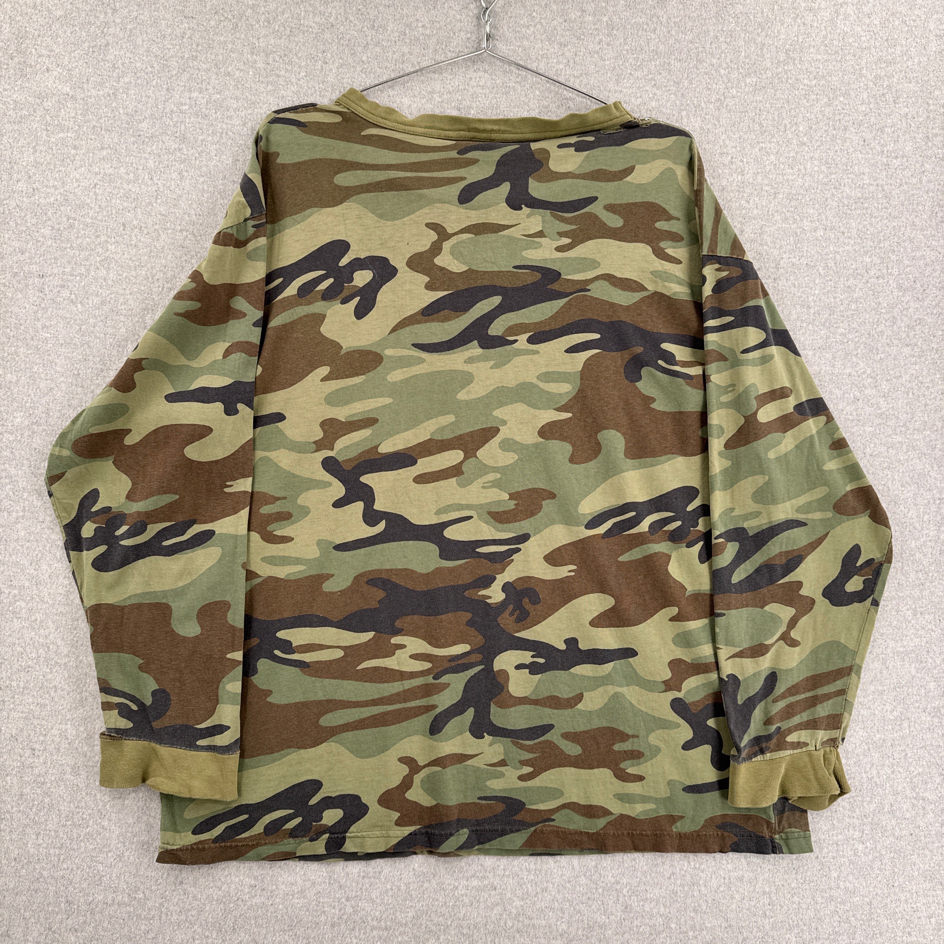 Folded camouflage shirt on a light gray background