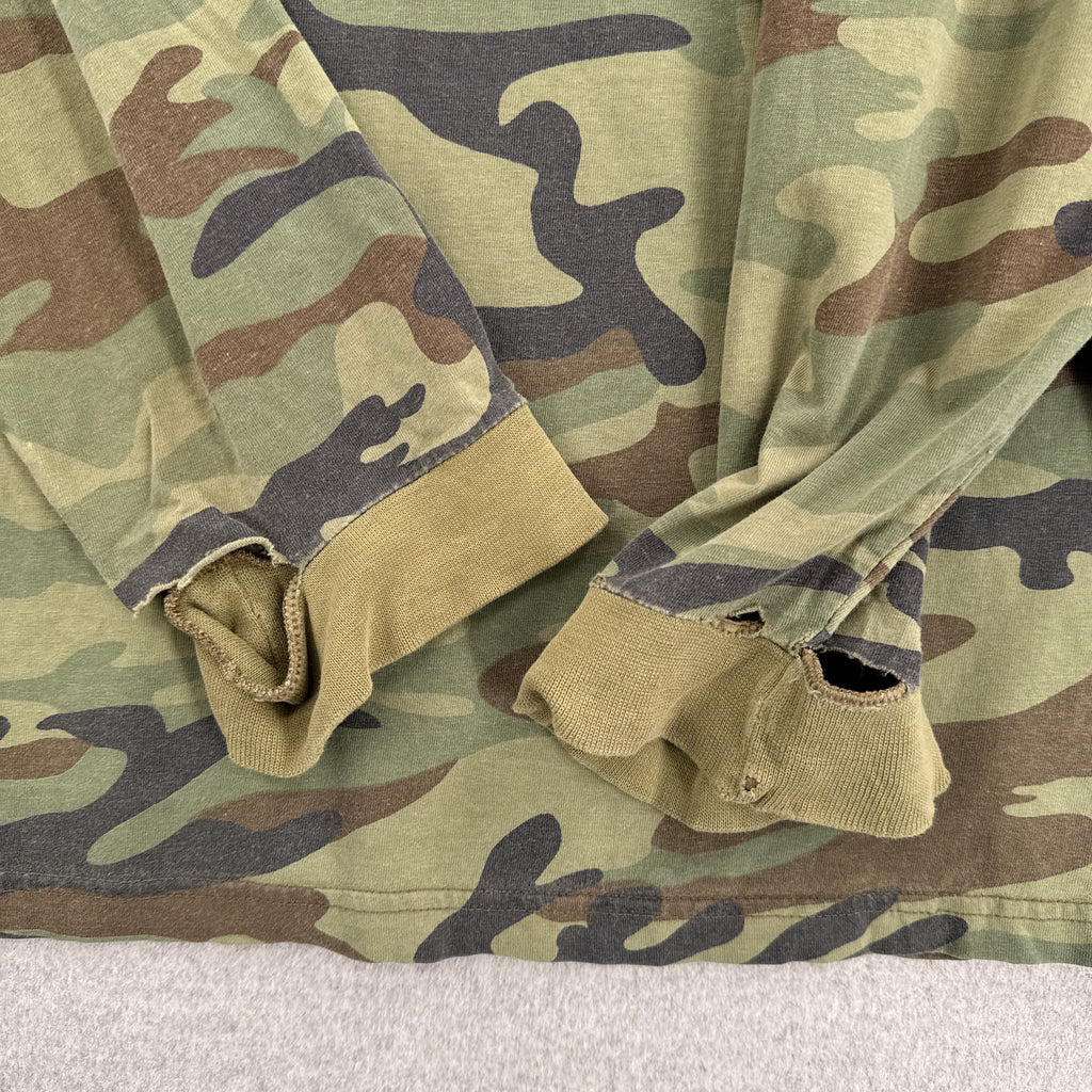 Close-up of camouflage fabric with a neutral background. Sleeves with major holes