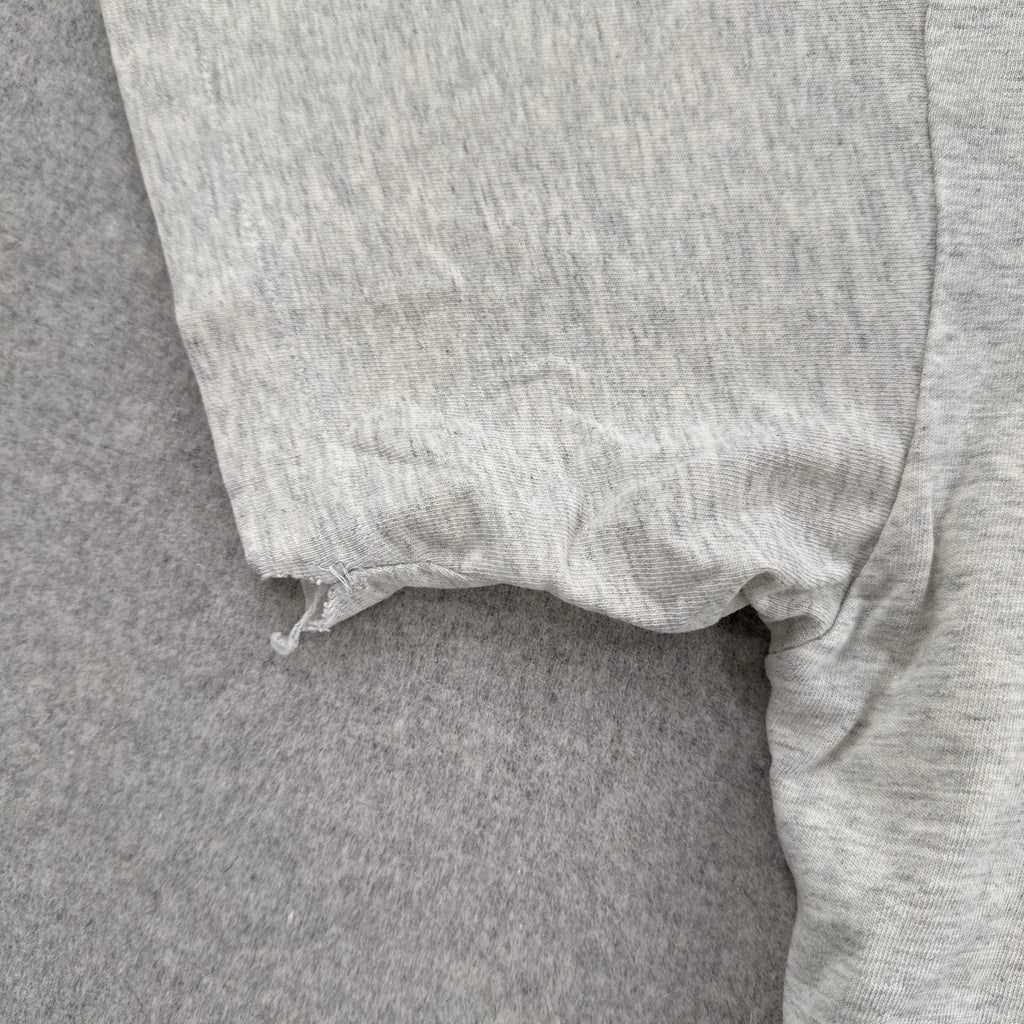 Close-up of gray fabric with a frayed edge on a matching background