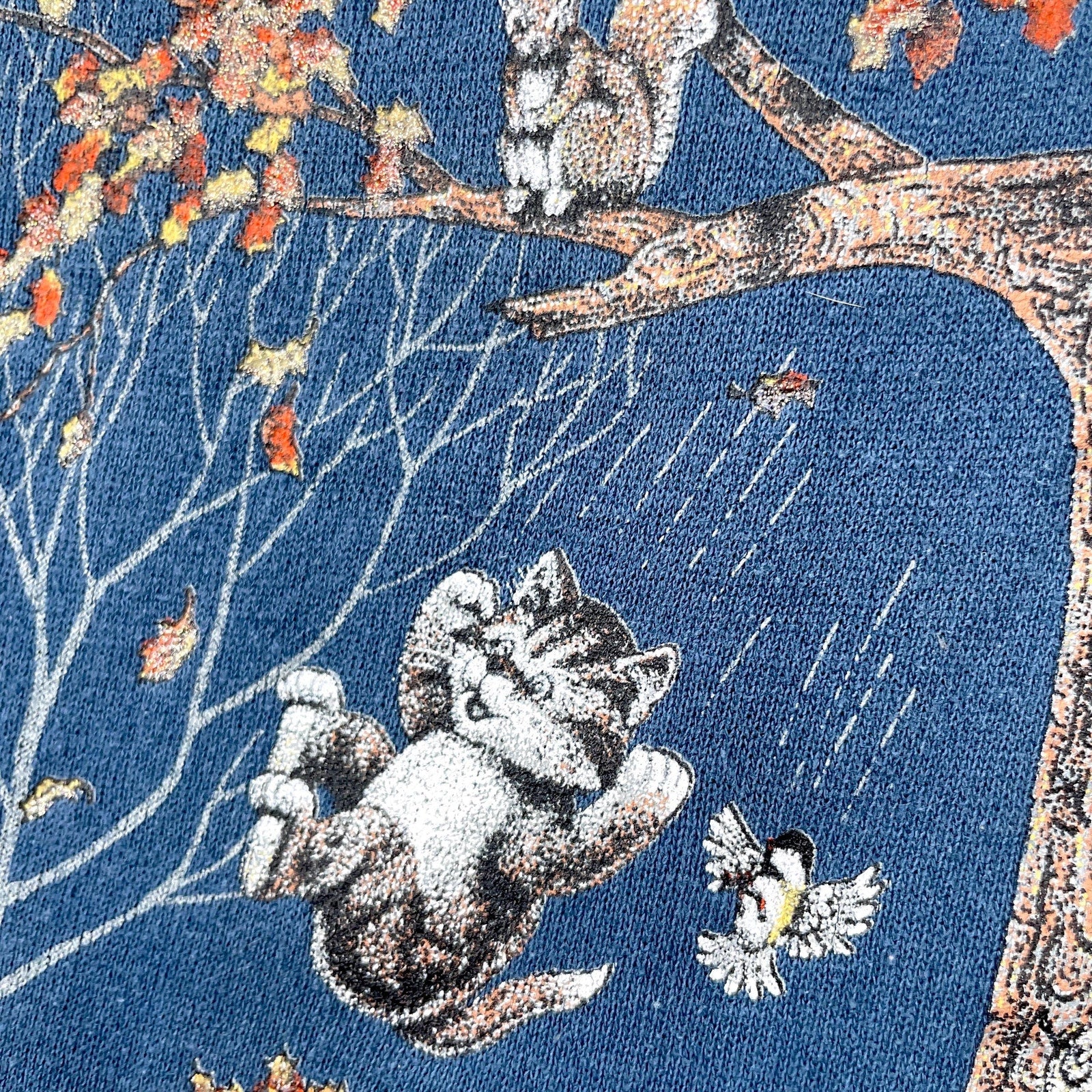 Cat lounging on a branch with birds and autumn leaves on a blue background