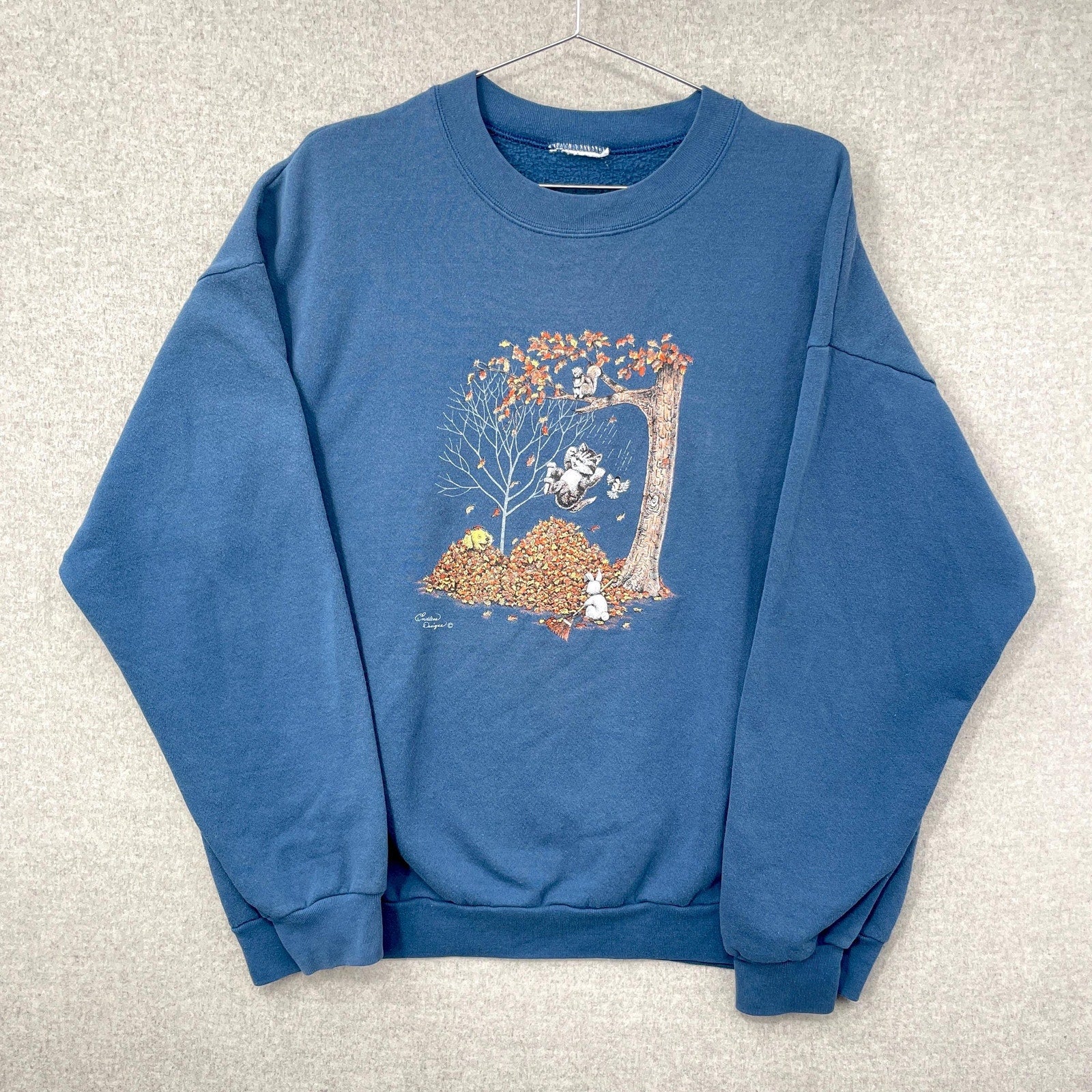 Blue sweatshirt with a graphic design on a light gray background
