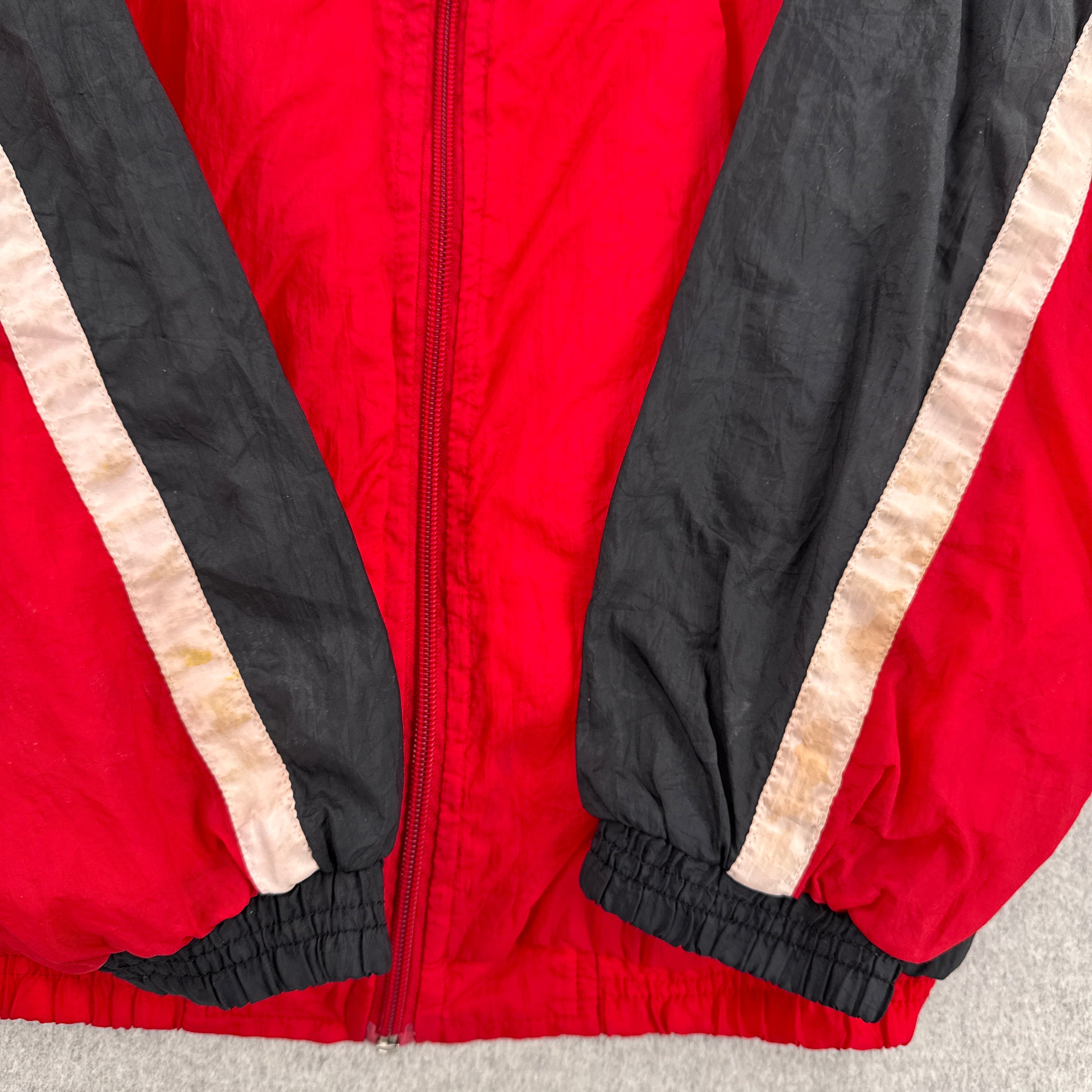 Red jacket with black and beige accents on a neutral background. discolouration stain on white fabric