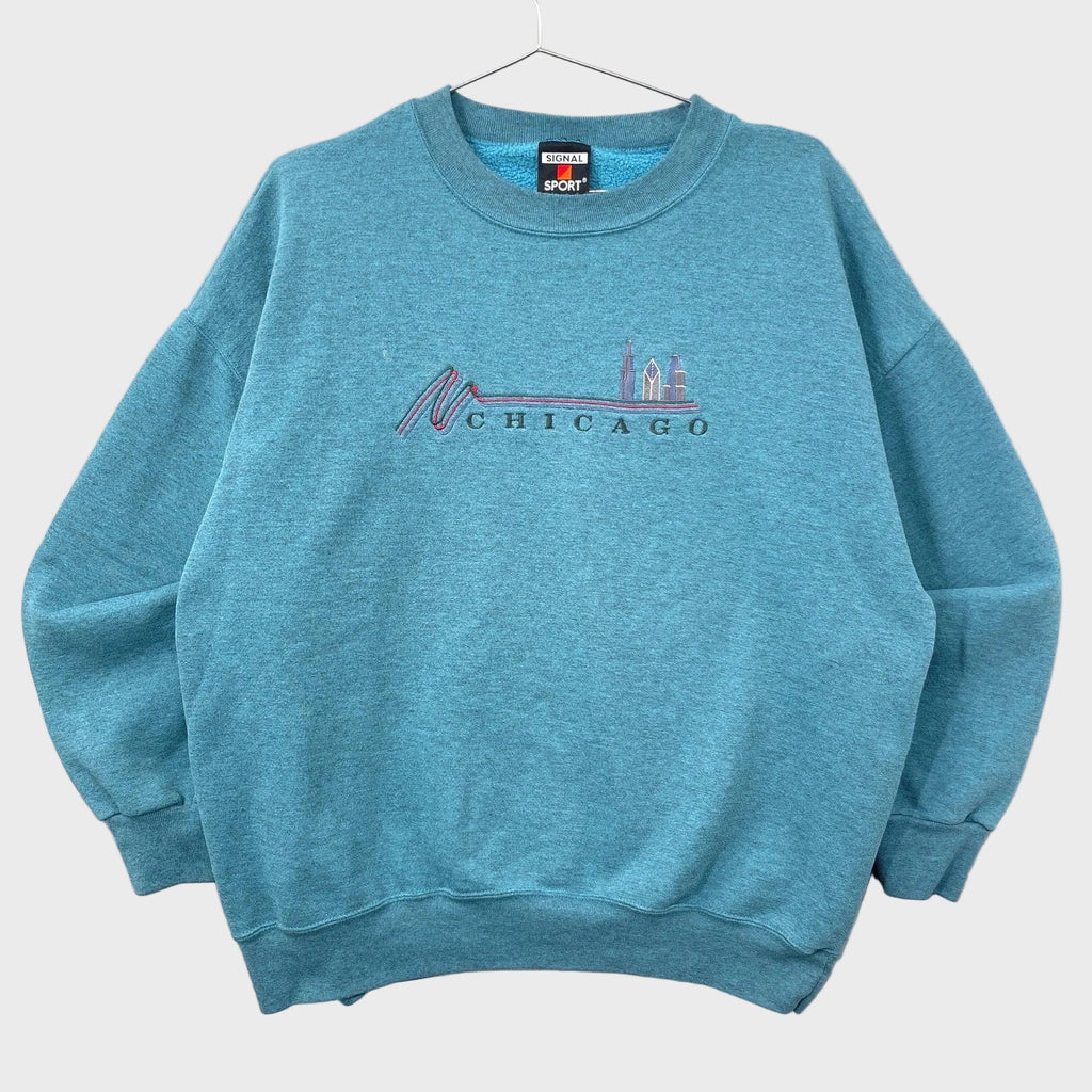 Blue sweatshirt with 'Chicago' skyline design on a textured surface