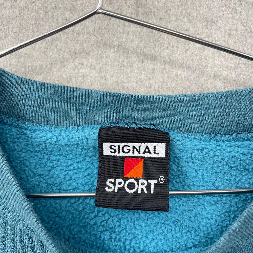 Blue fleece garment with Signal Sport label on a hanger