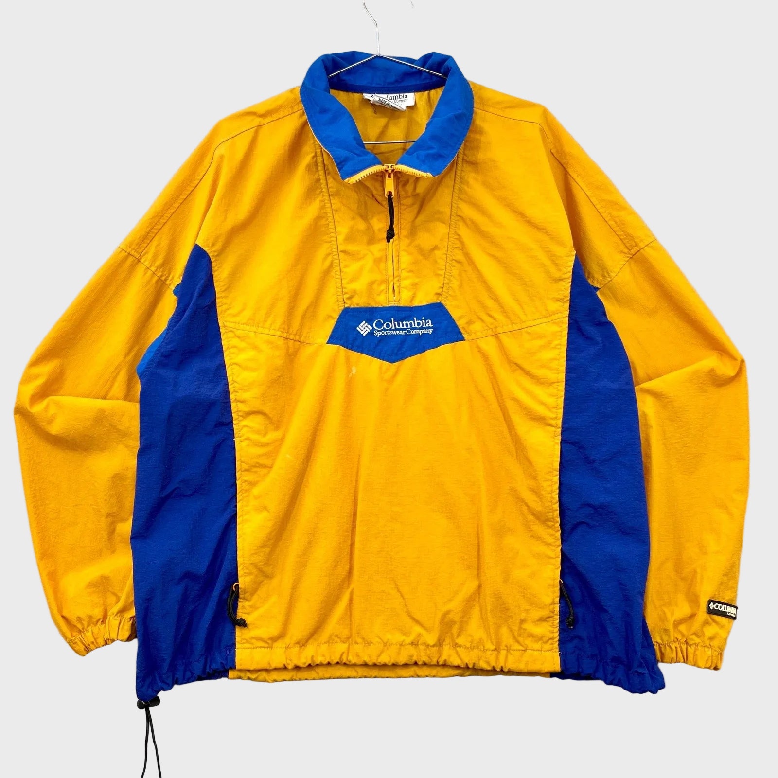 Yellow and blue jacket with Columbia logo on a gray background