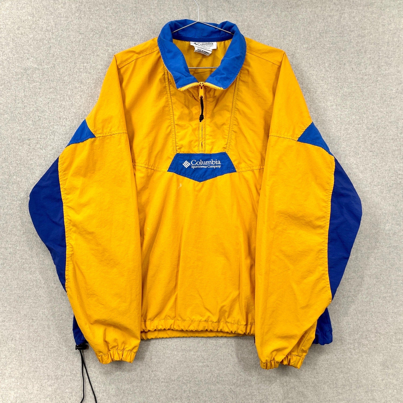Yellow and blue Columbia jacket on a gray background