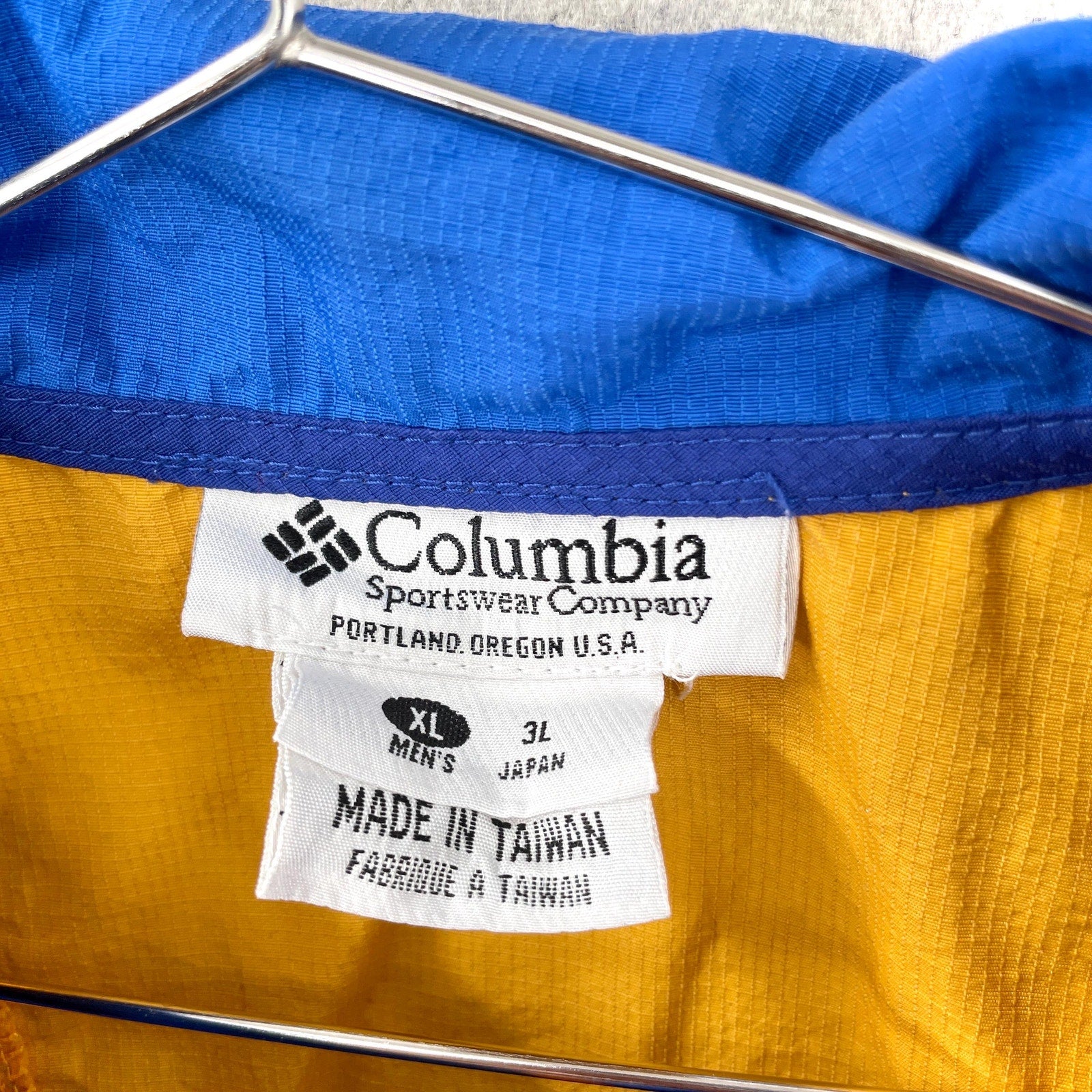 Columbia Sportswear Company label on a jacket with blue and yellow fabric. size mens XL