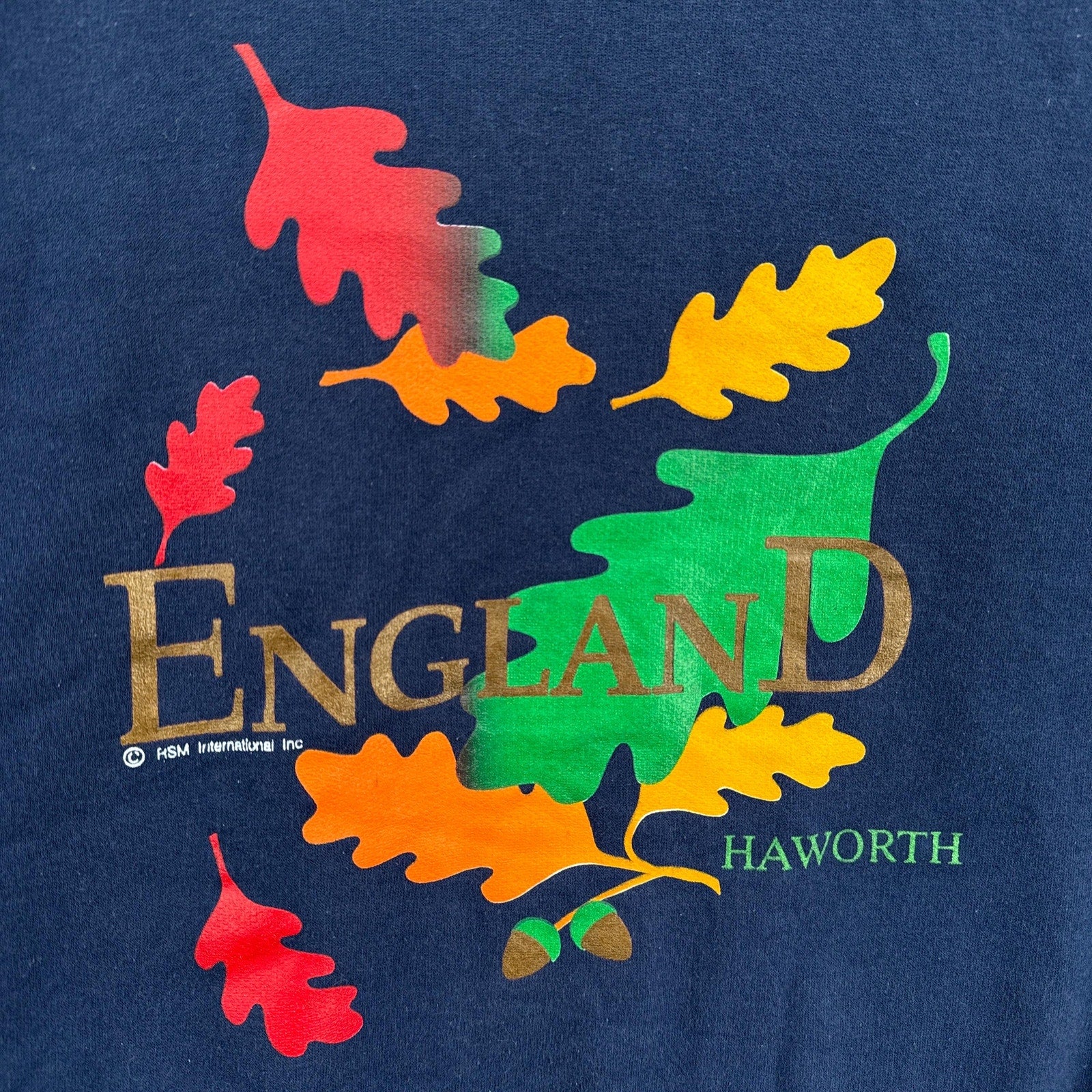 Navy blue sweatshirt with colorful leaf design and 'England Haworth' text