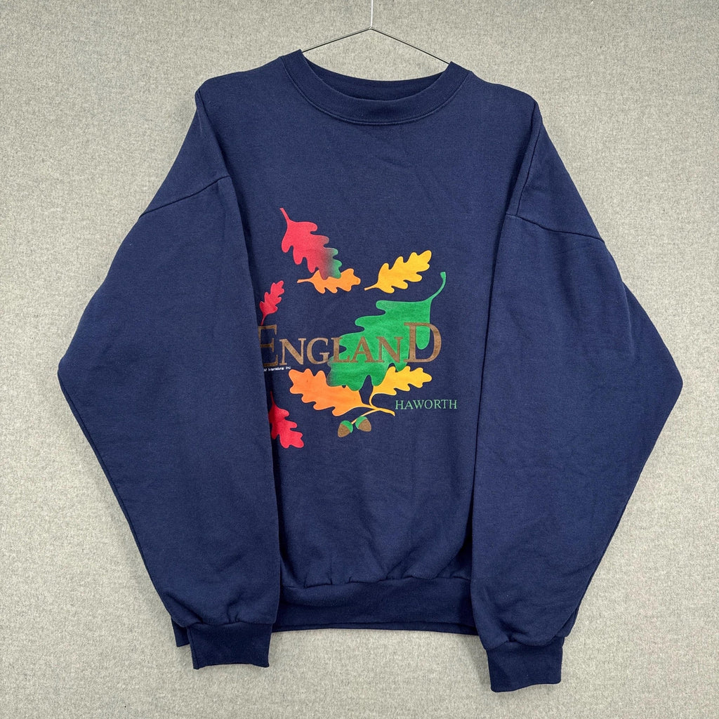 Navy blue sweatshirt with colorful leaf design and 'England' text on a gray background