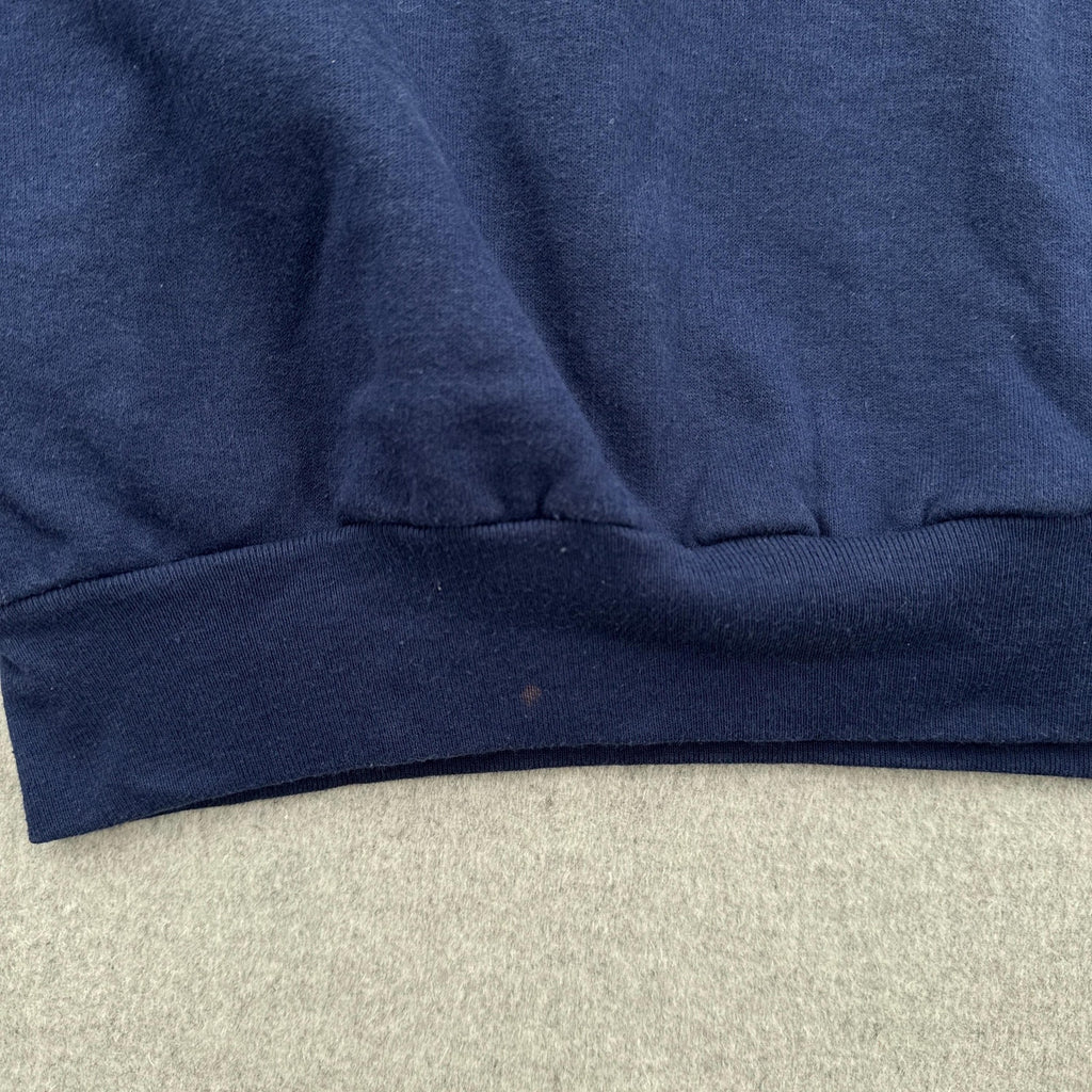 Close-up of a blue fabric edge on a textured surface with a small stain spot