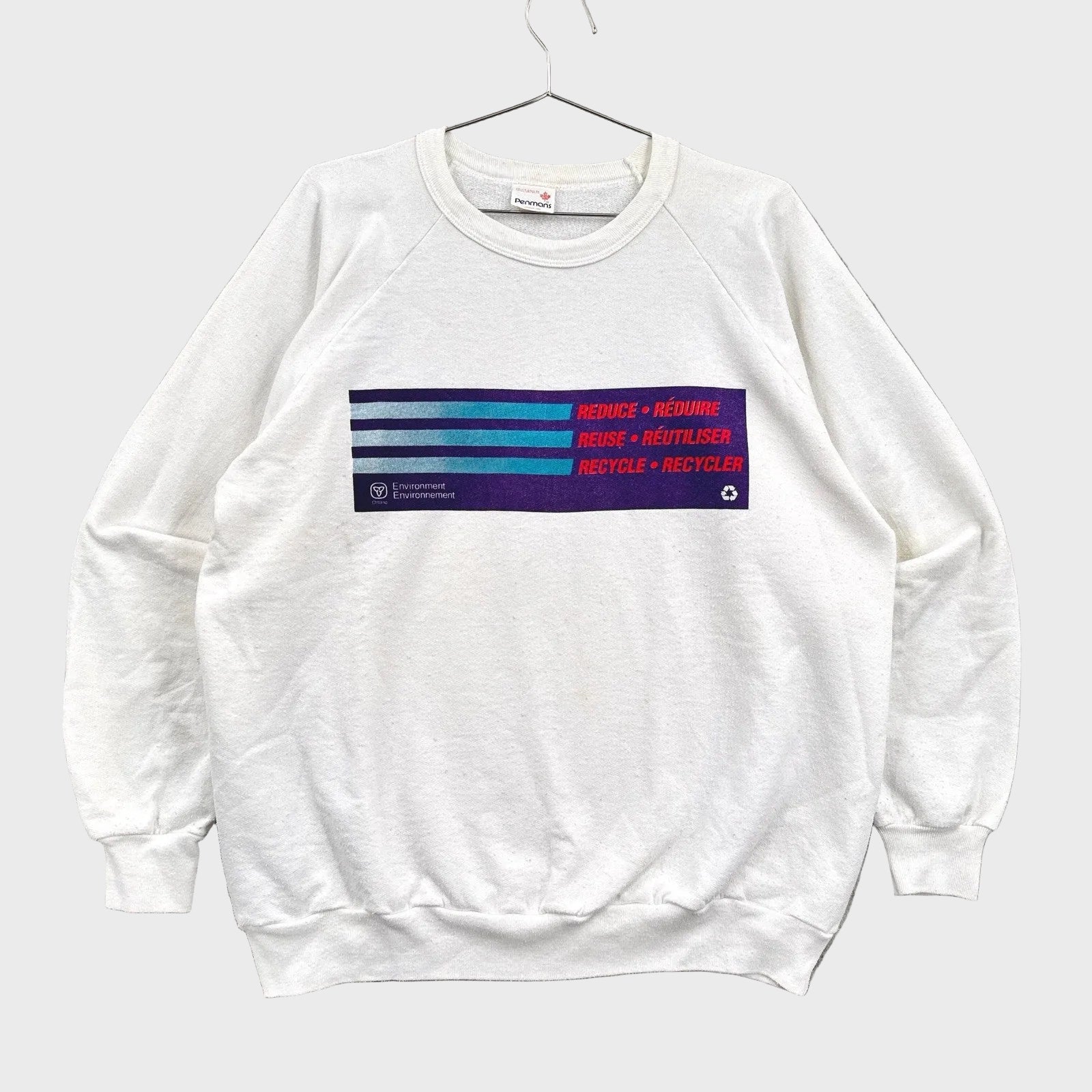 White sweatshirt with colorful text and logo on a gray background