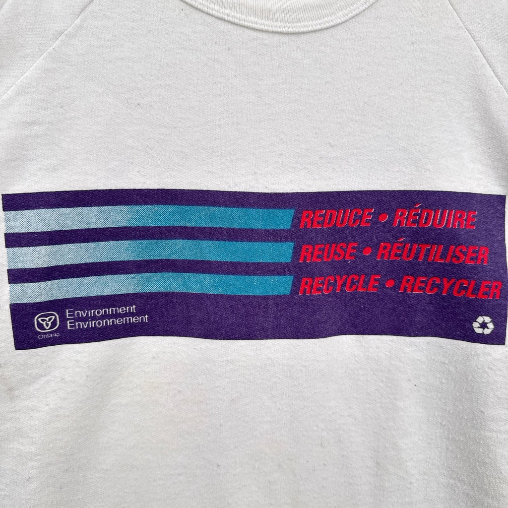 Gray sweatshirt with a recycling message in English and French on a purple stripe.