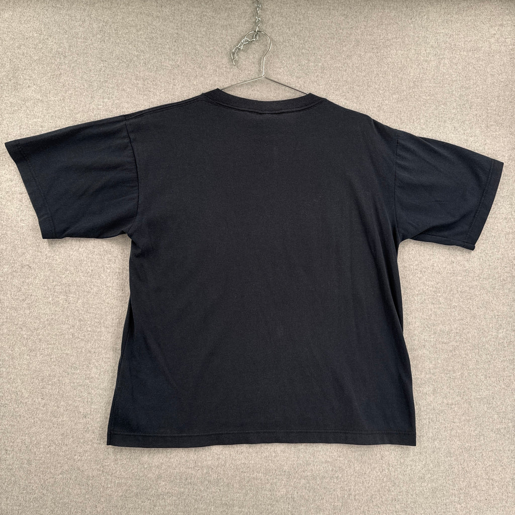 Black tee shirt on a beige textured surface