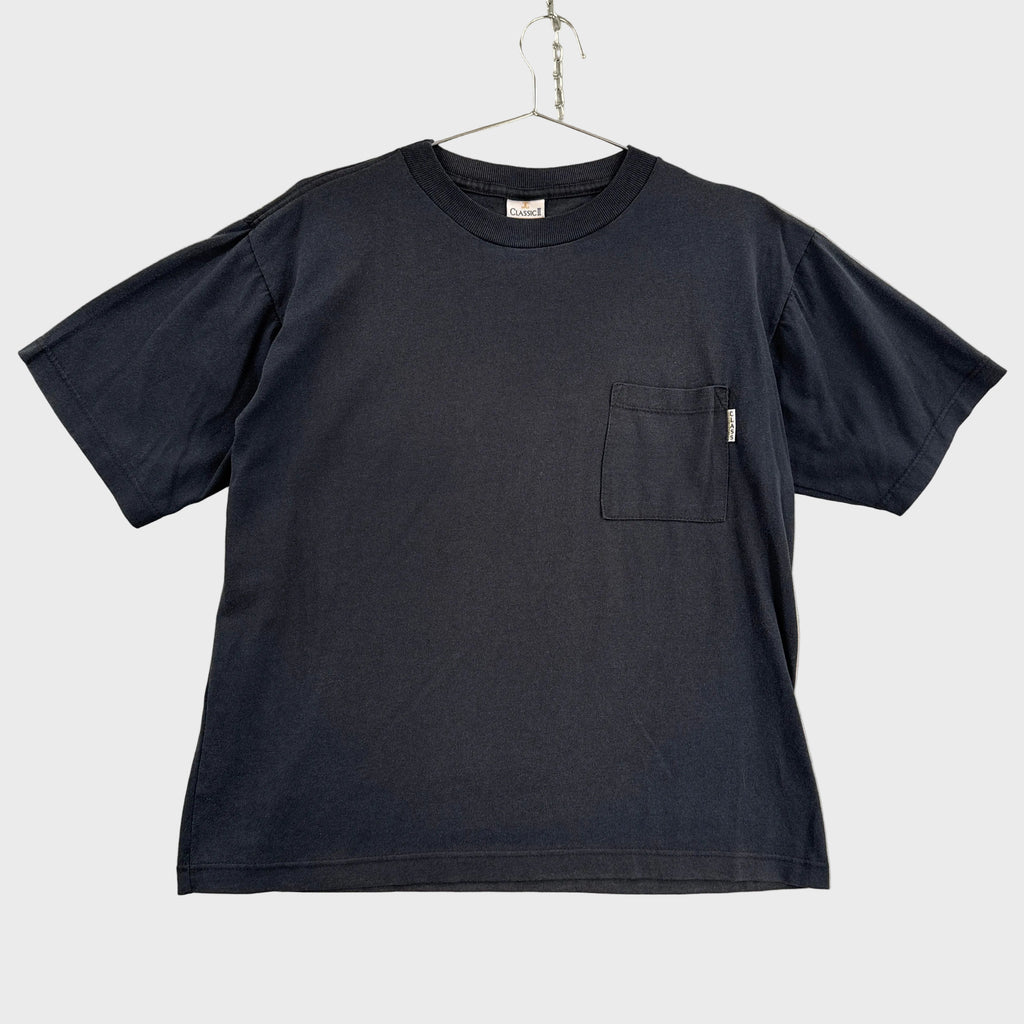 Black t-shirt with a pocket on a beige surface