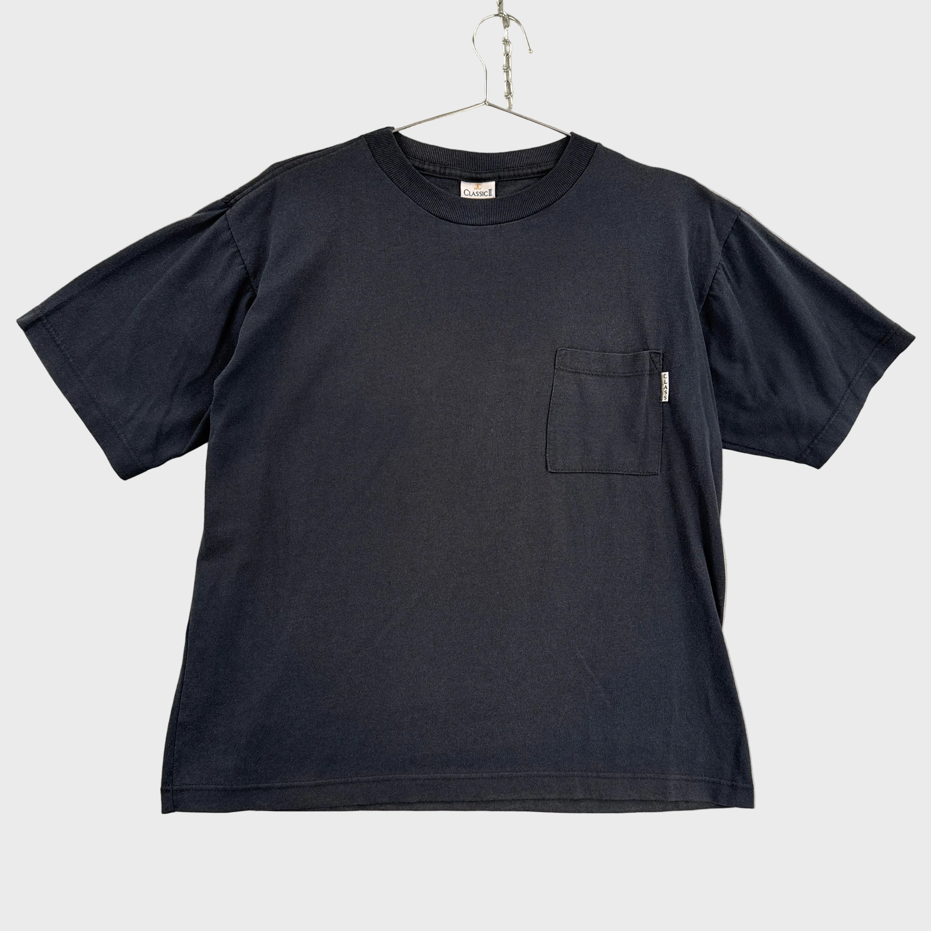 Black t-shirt with a pocket on a beige surface