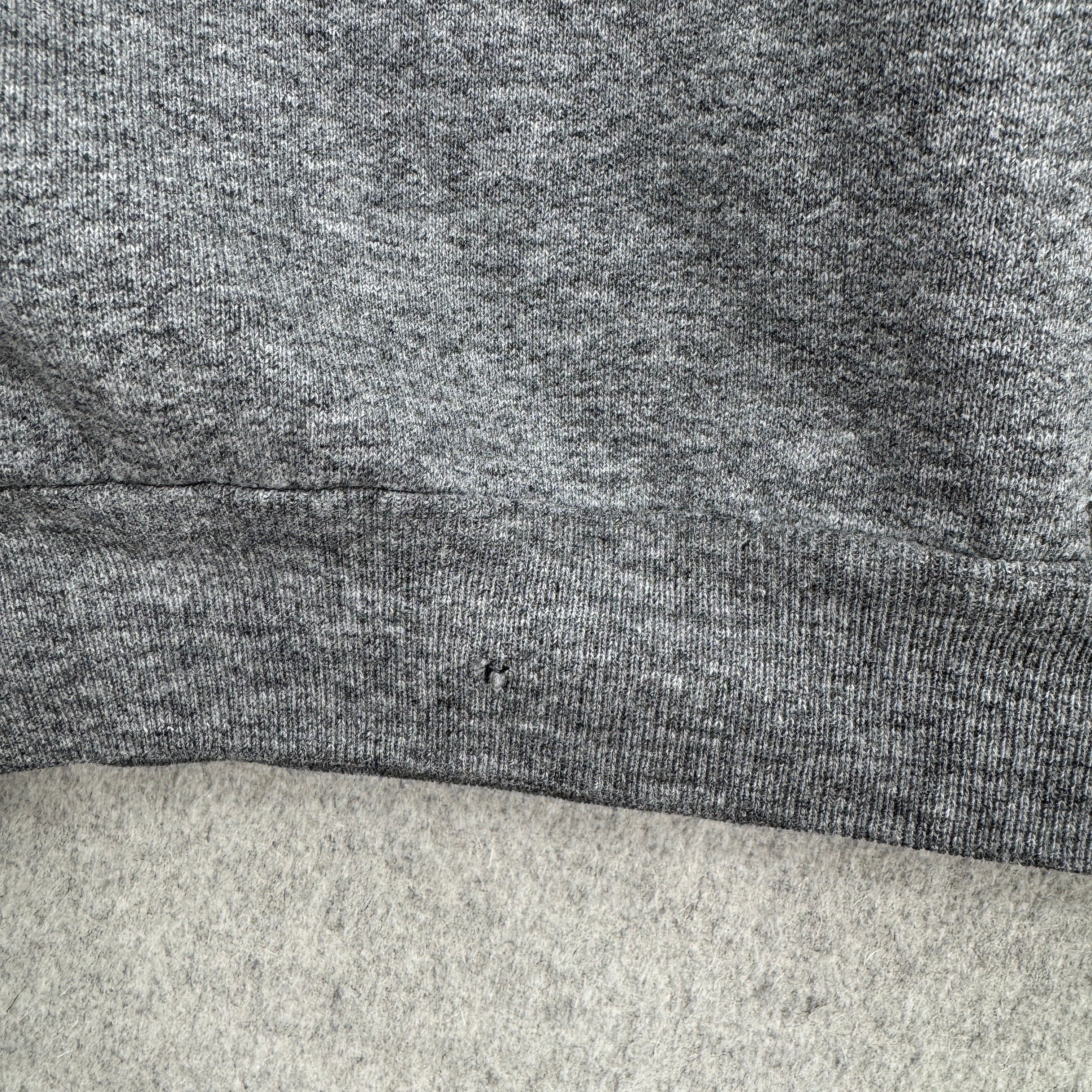 Close-up of a gray fabric texture with a small hole