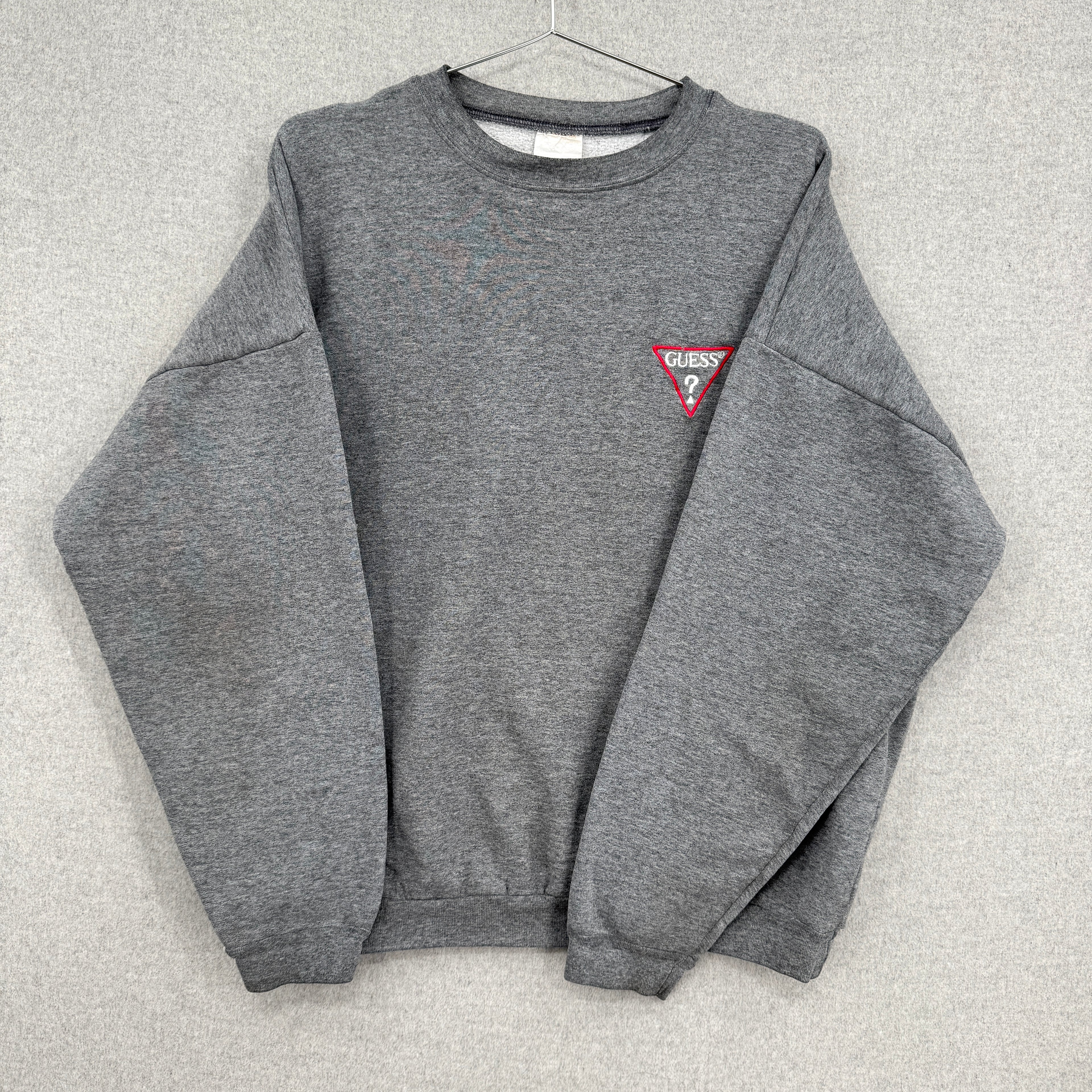 Gray sweatshirt with a small logo on a light gray background