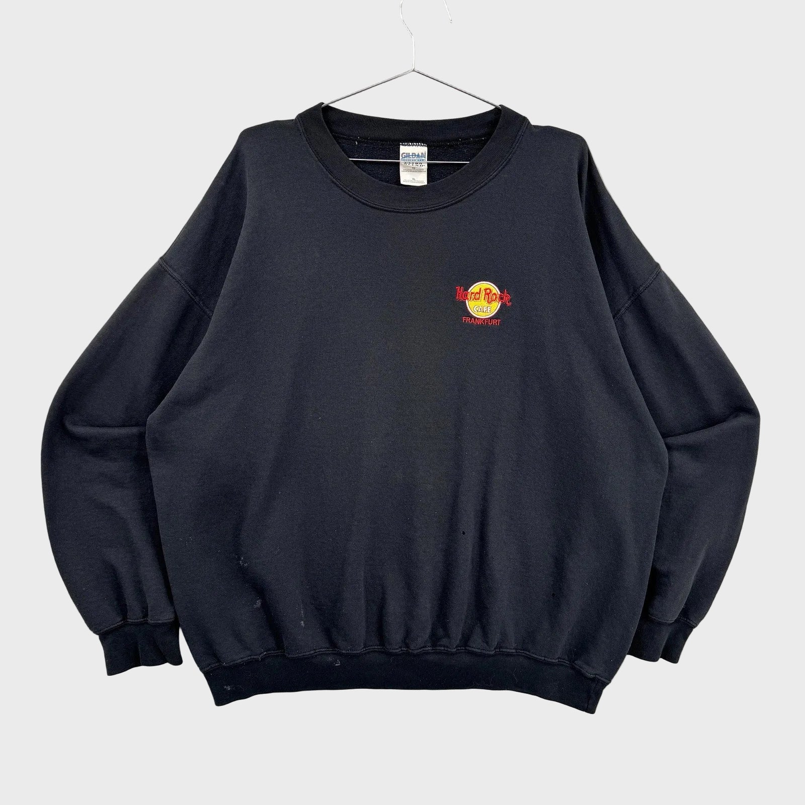 Black sweatshirt with a logo on a gray background