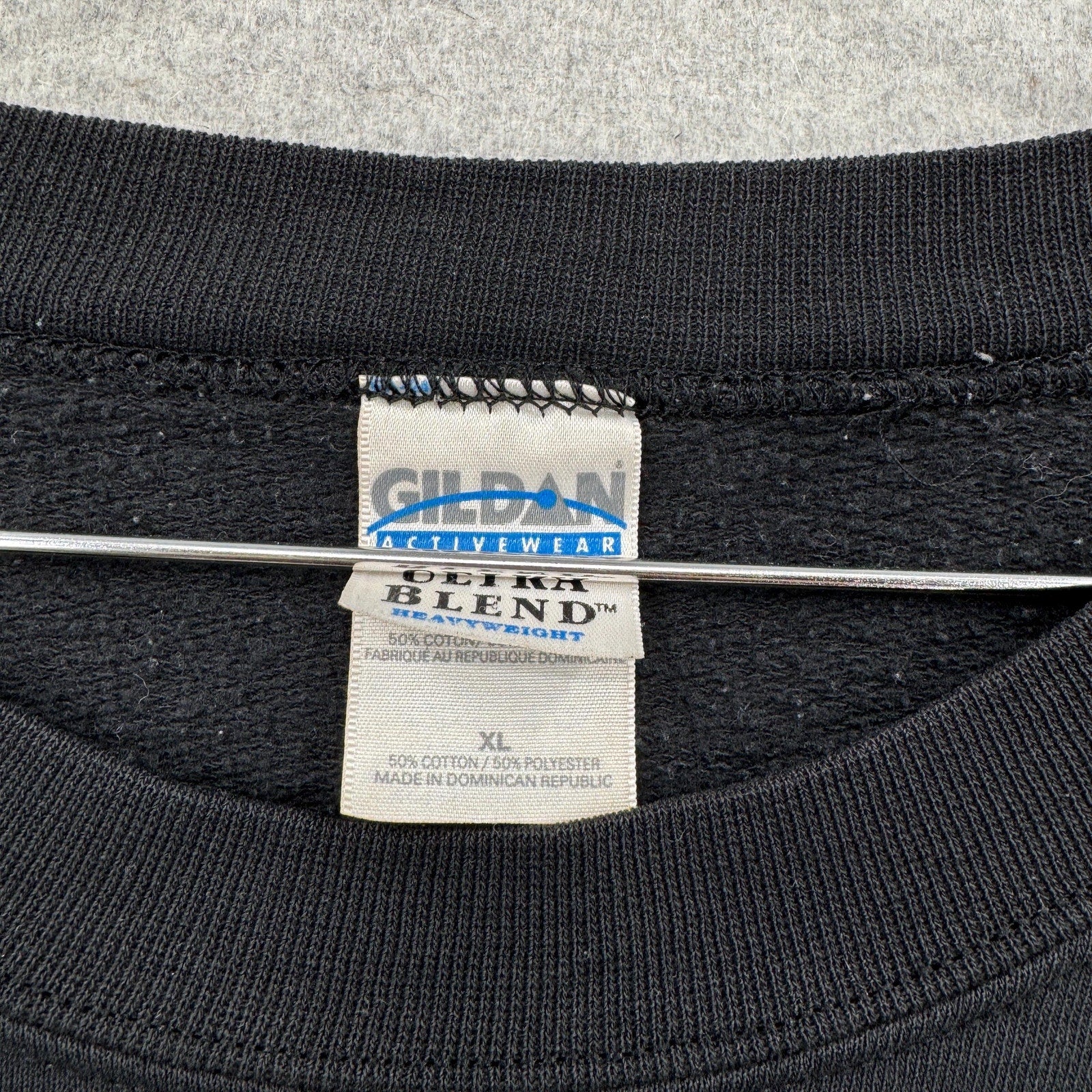 Gildan Activewear label on a black shirt with gray background. size XL