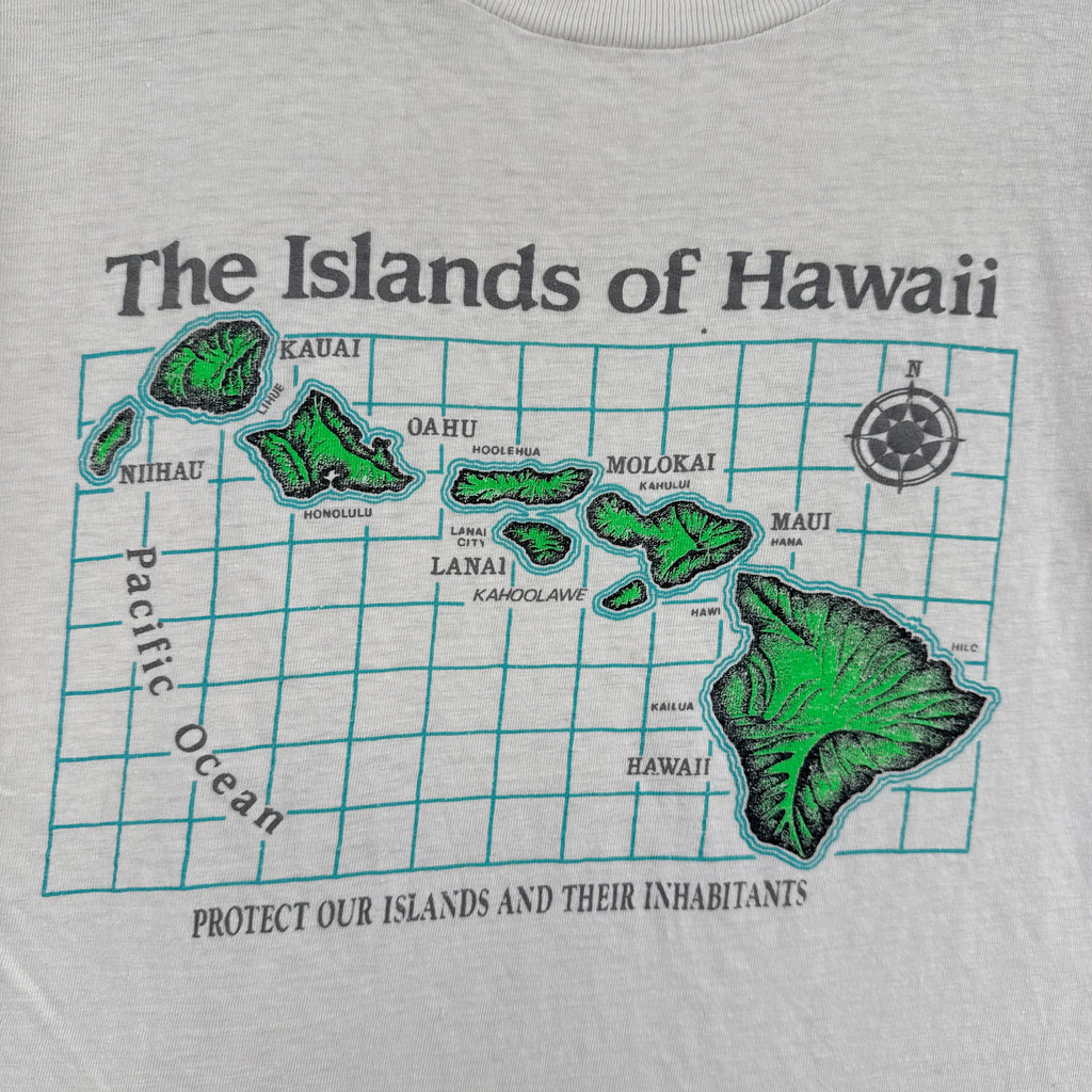 White t-shirt with a map of Hawaii in green and black text on a white background