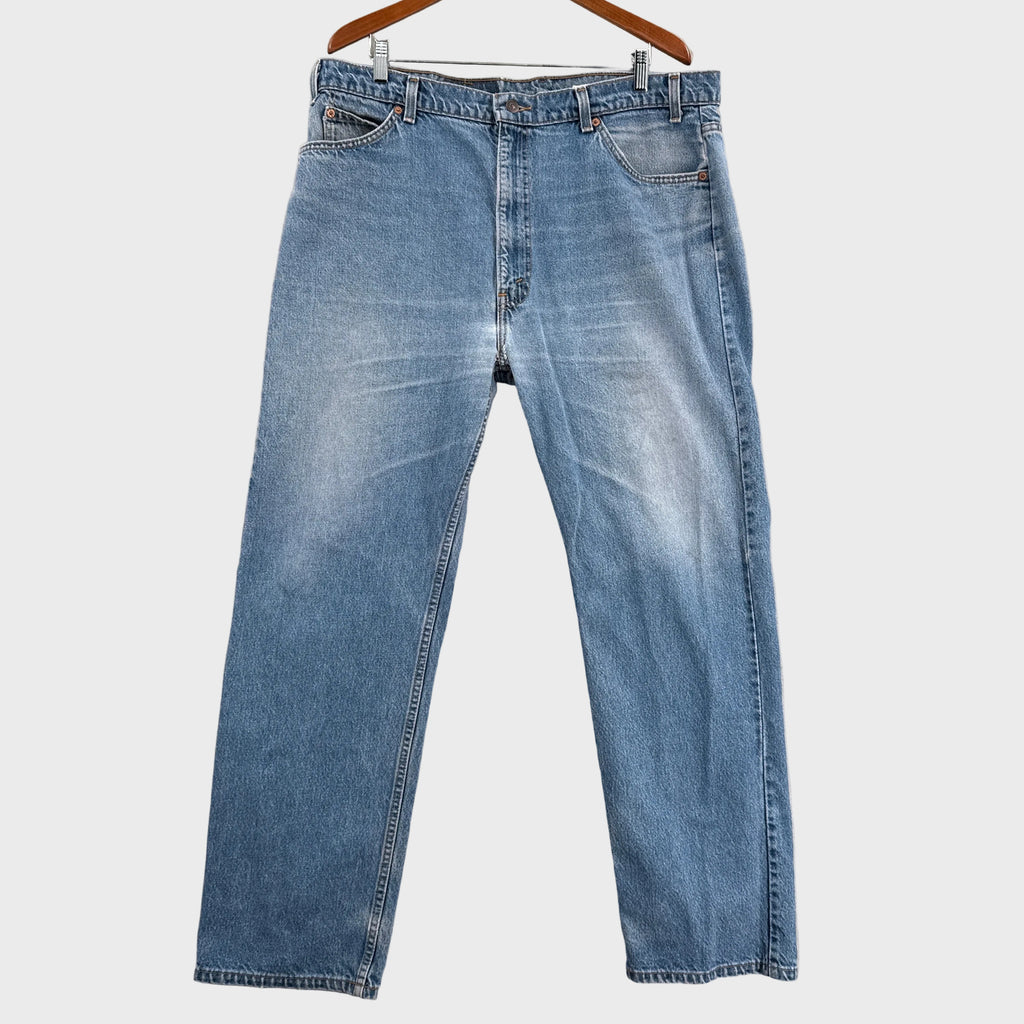 Blue jeans on a hanger against a neutral background