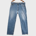 Blue jeans on a hanger against a neutral background