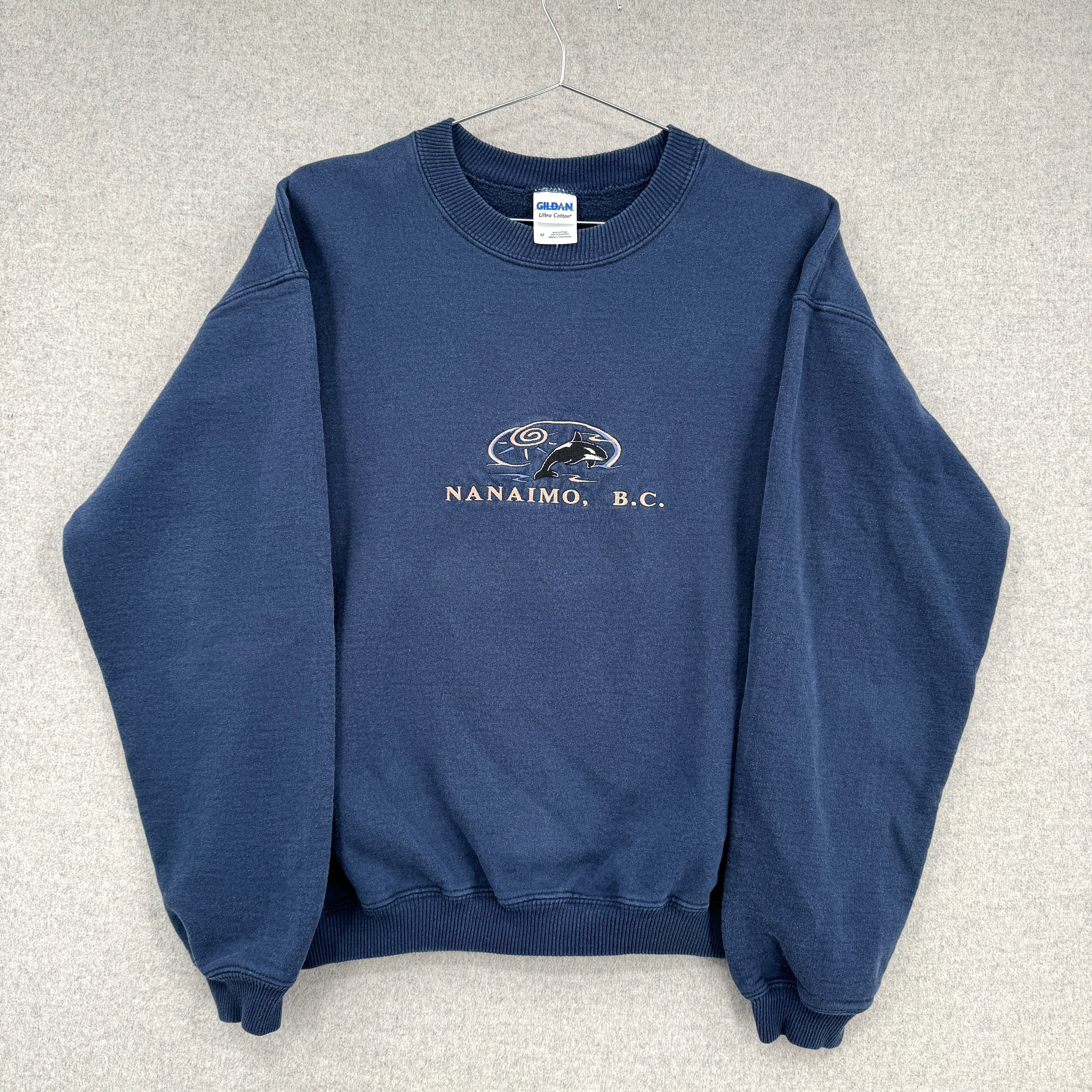 Blue sweatshirt with 'Nanaimo, B.C.' text and logo on a gray background