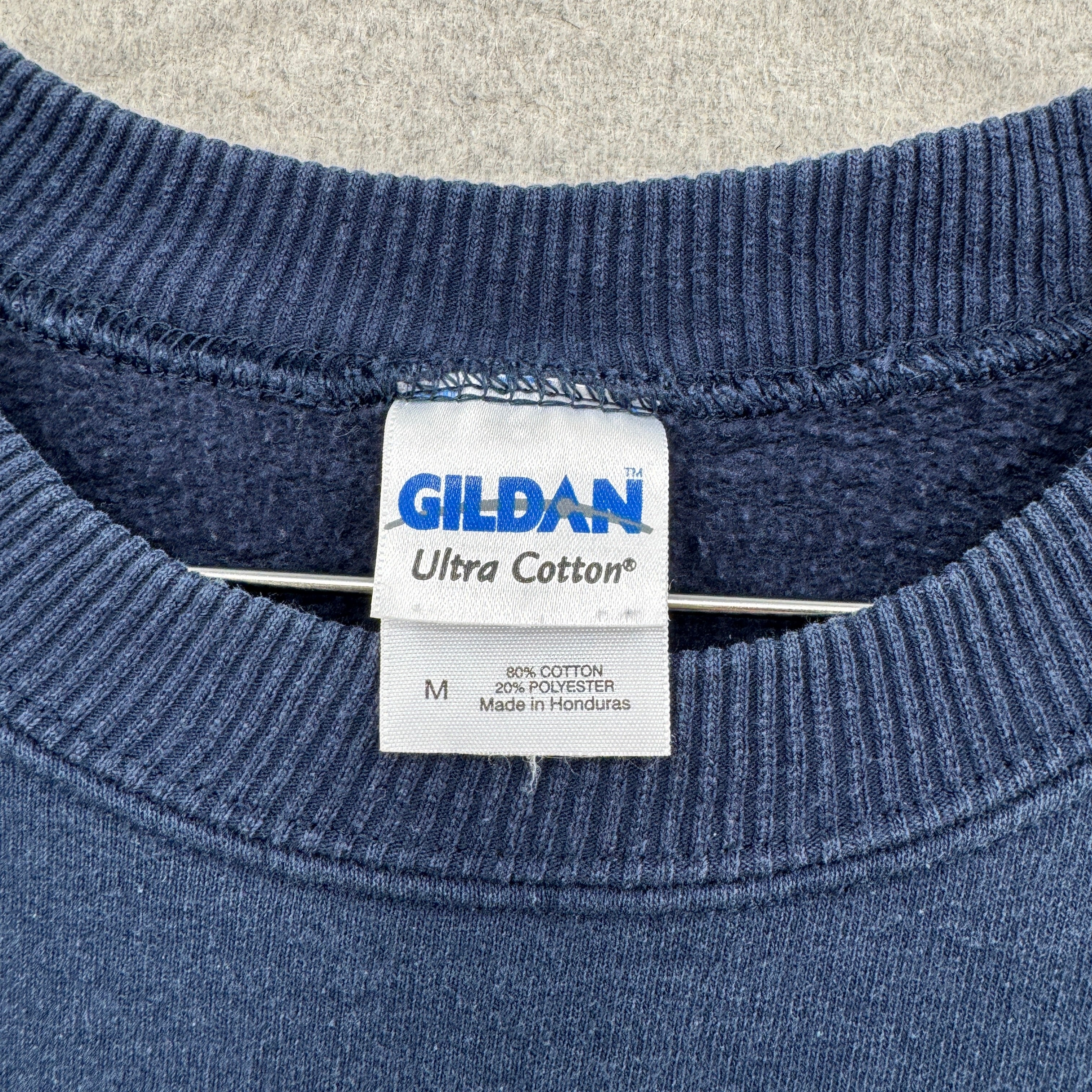 Gildan Ultra Cotton tag on a blue shirt, Ultra Cotton, Medium, 80% cotton 20% polyester