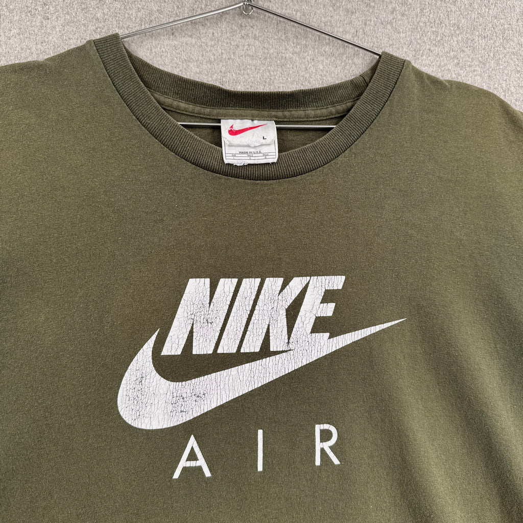 Green Nike Air t-shirt on a hanger with a visible brand label.