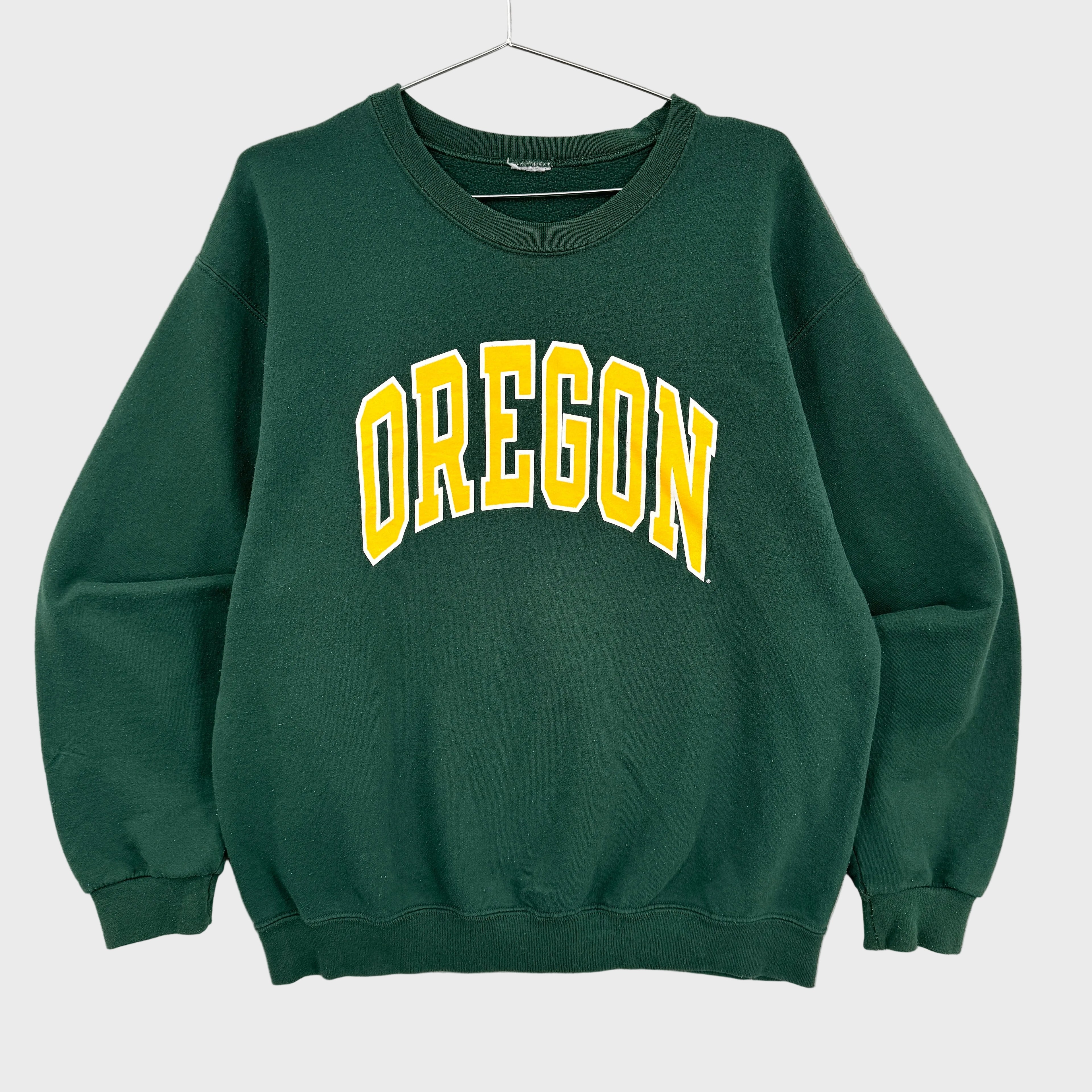 Green sweatshirt with 'OREGON' printed in yellow on a gray background