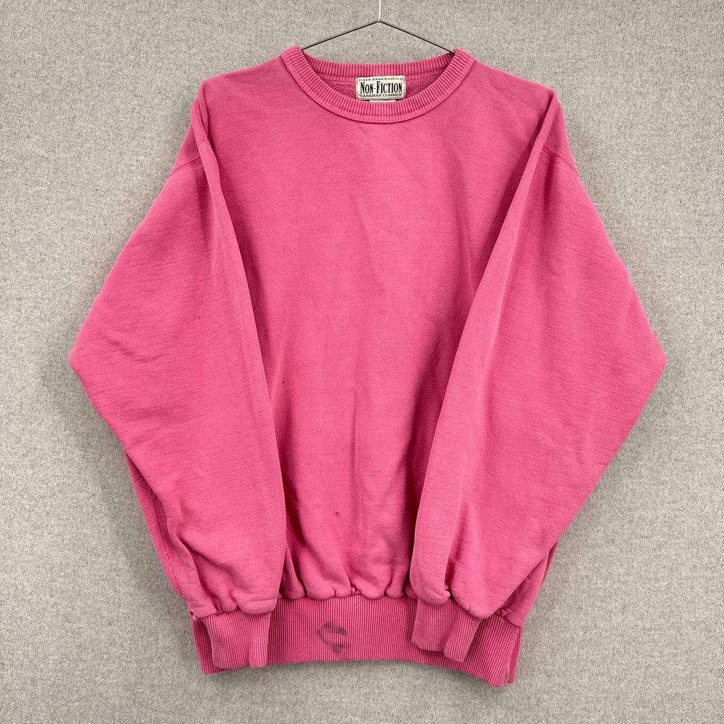 Pink sweatshirt on a hanger against a gray background