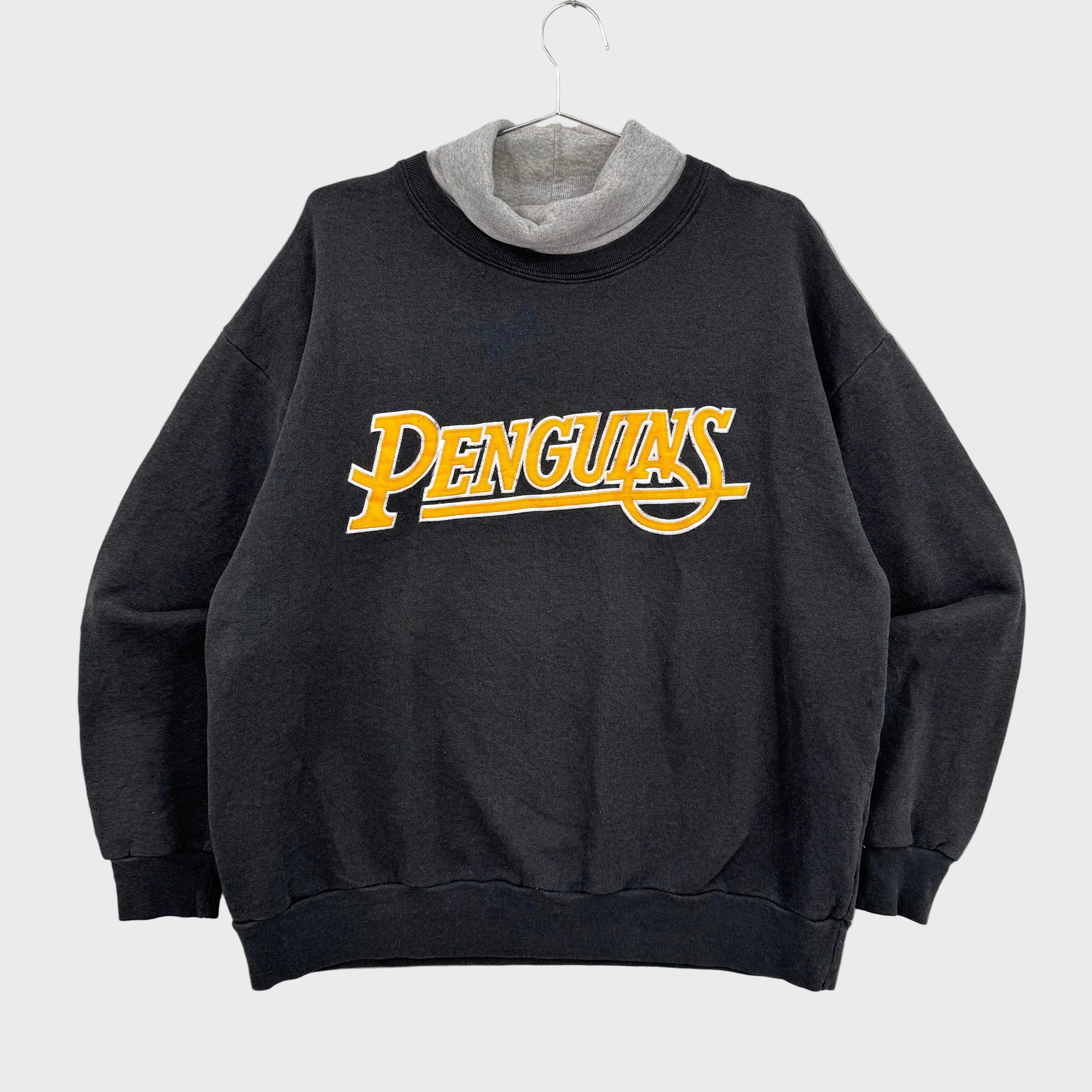 Black sweatshirt with 'PENGUINS' text on a gray background