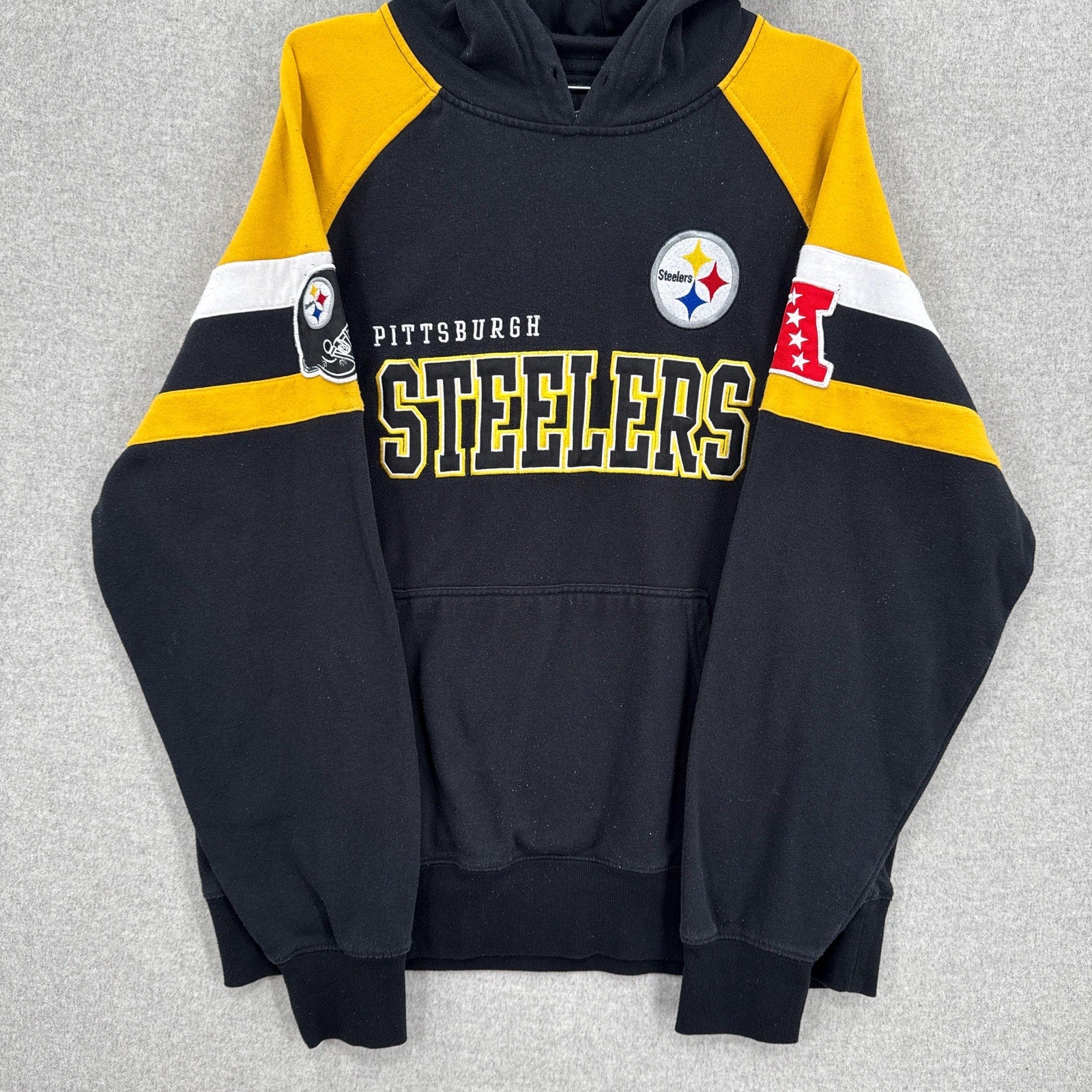 Black Pittsburgh Steelers hoodie with yellow and white accents on a gray background