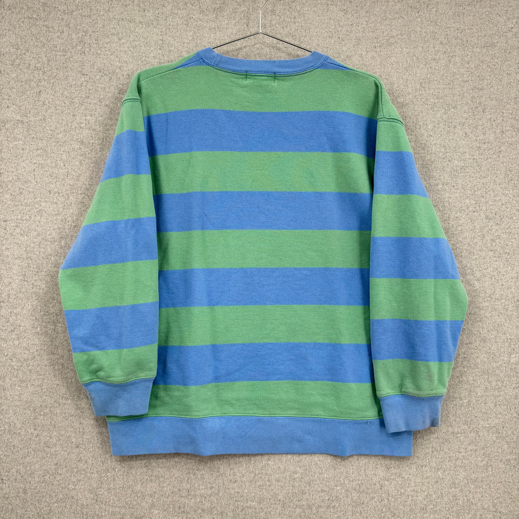 Blue and green striped sweater on a beige background