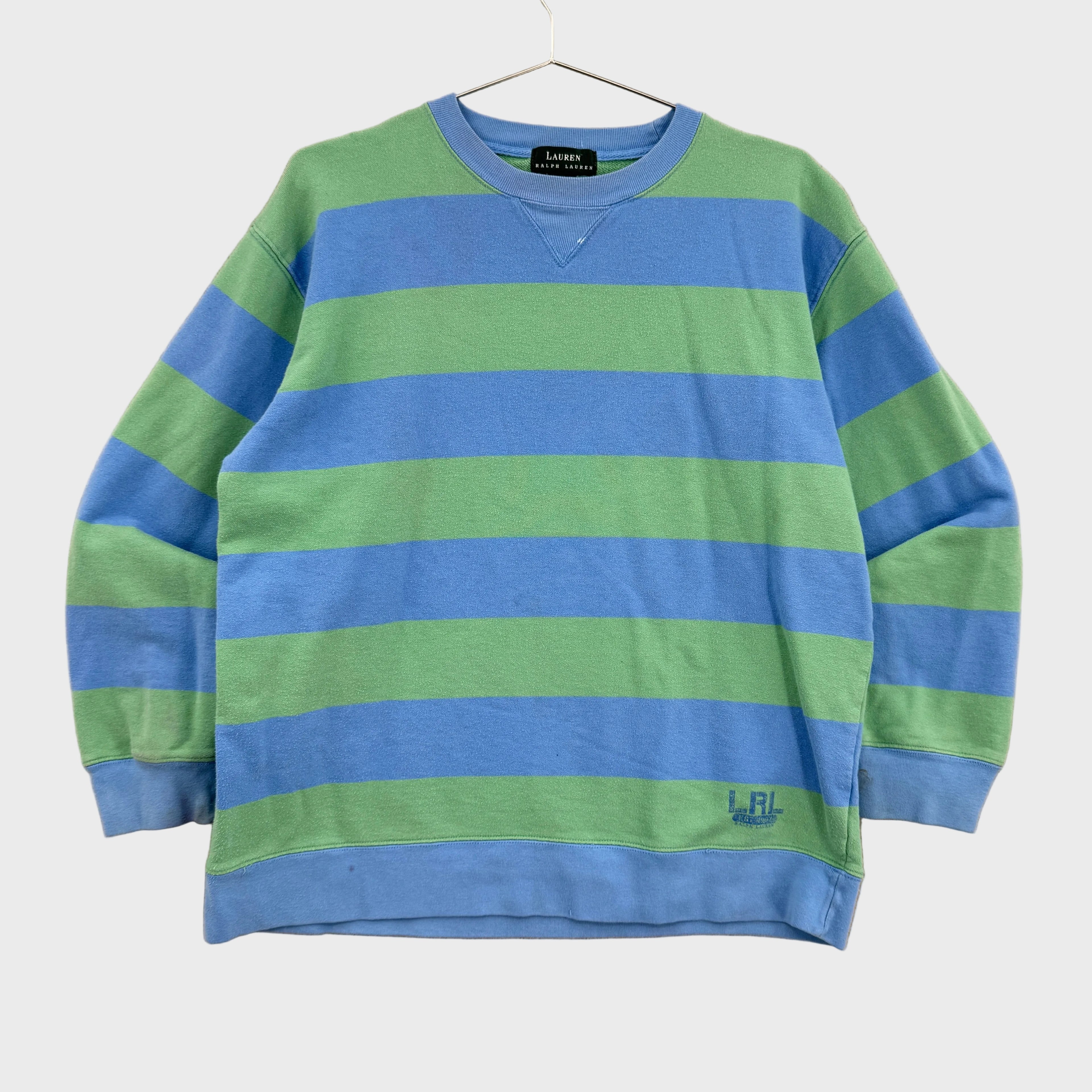 Blue and green striped sweater on a beige background