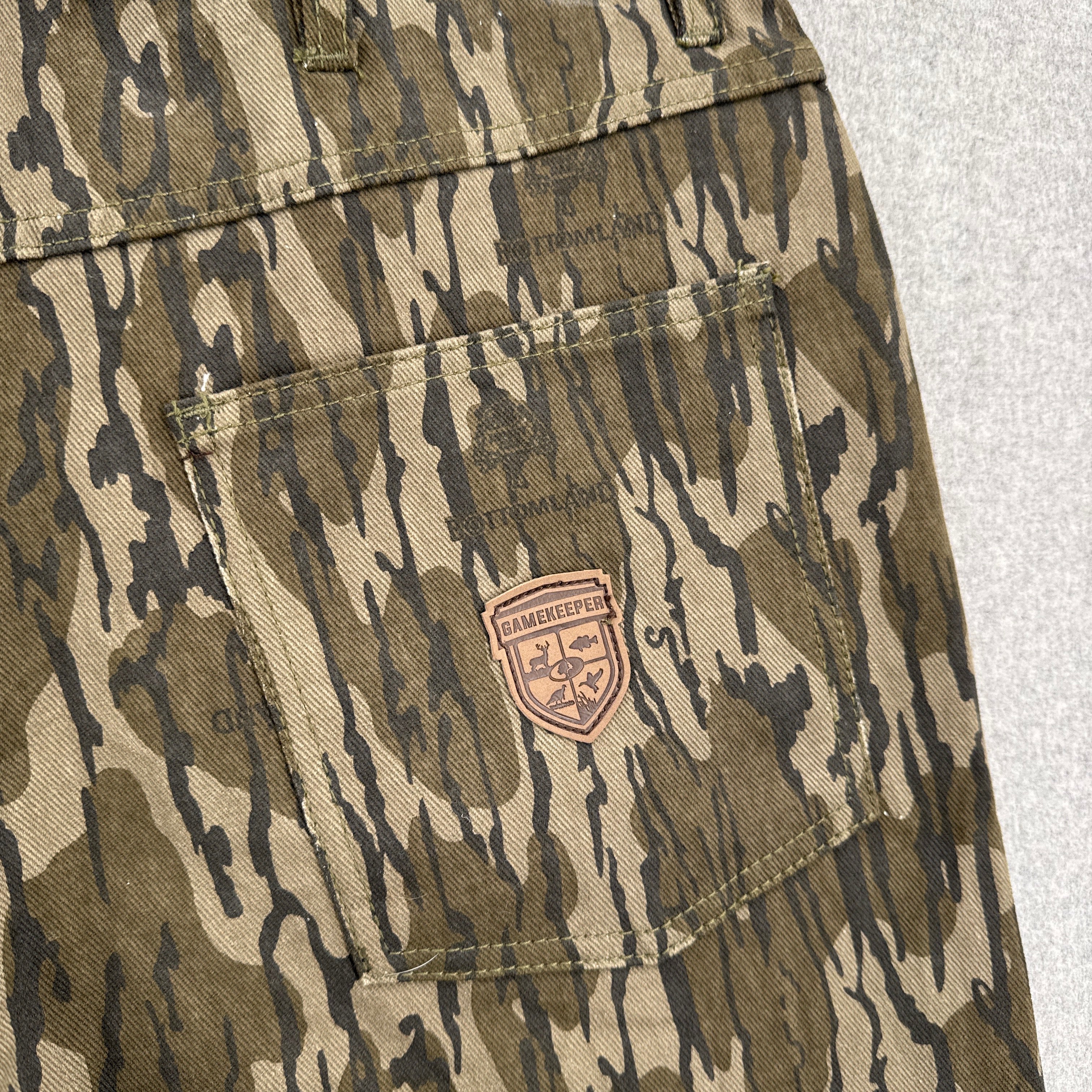 Camouflage pants with a brand logo on a light gray background
