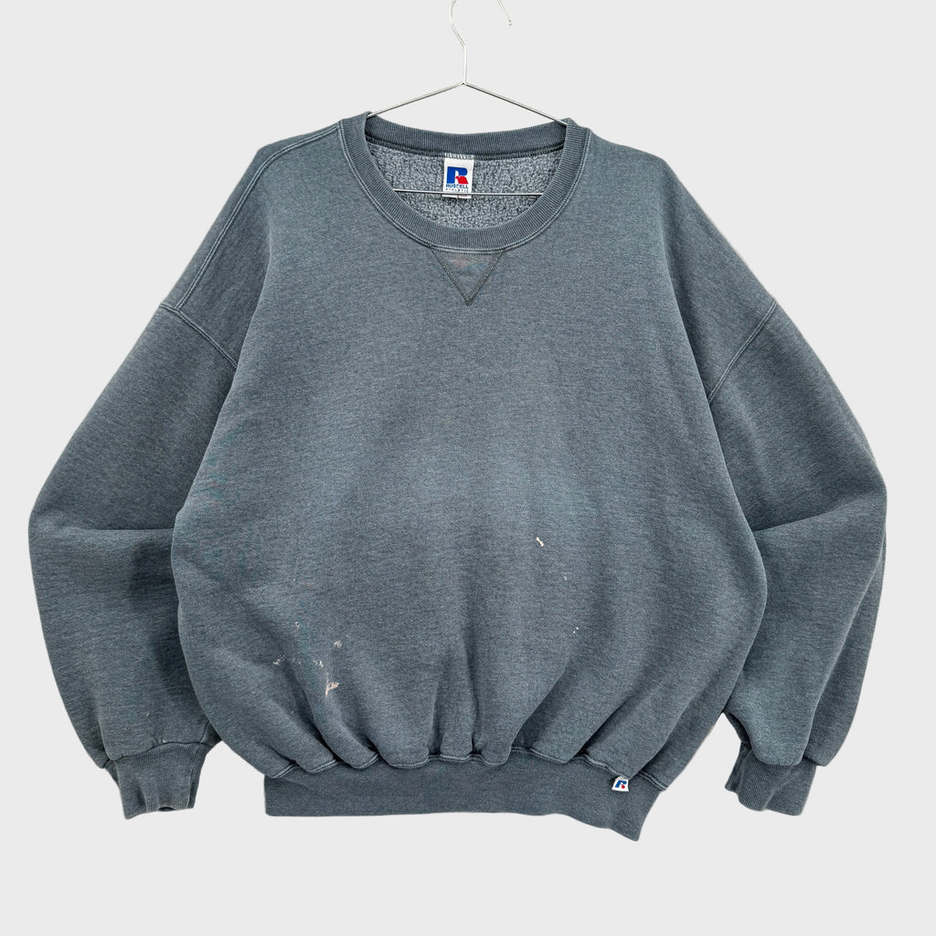 Gray sweatshirt on a hanger with a visible brand label against a neutral background