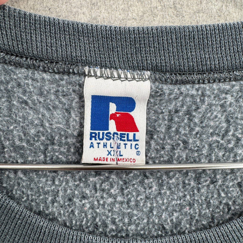Gray sweatshirt with a Russell Athletic label on a textured gray background. Made in Mexico size 2XL