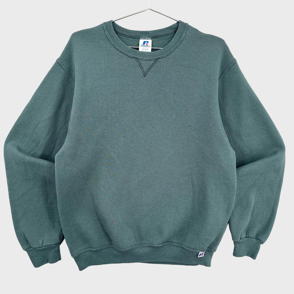 Green sweatshirt on a hanger with a visible brand label against a neutral background