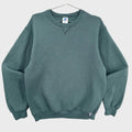 Green sweatshirt on a hanger with a visible brand label against a neutral background