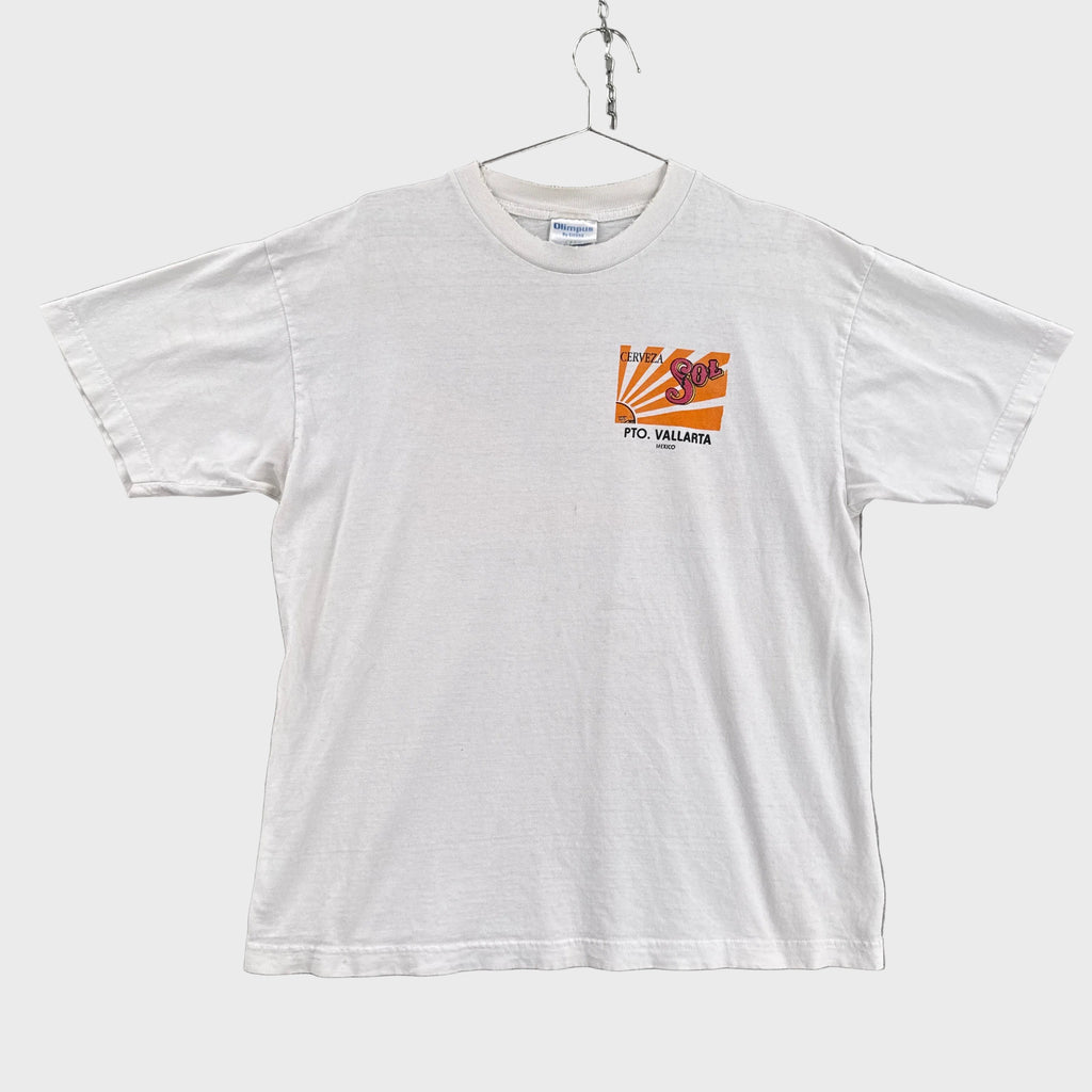 White t-shirt with a small chest logo on a gray background