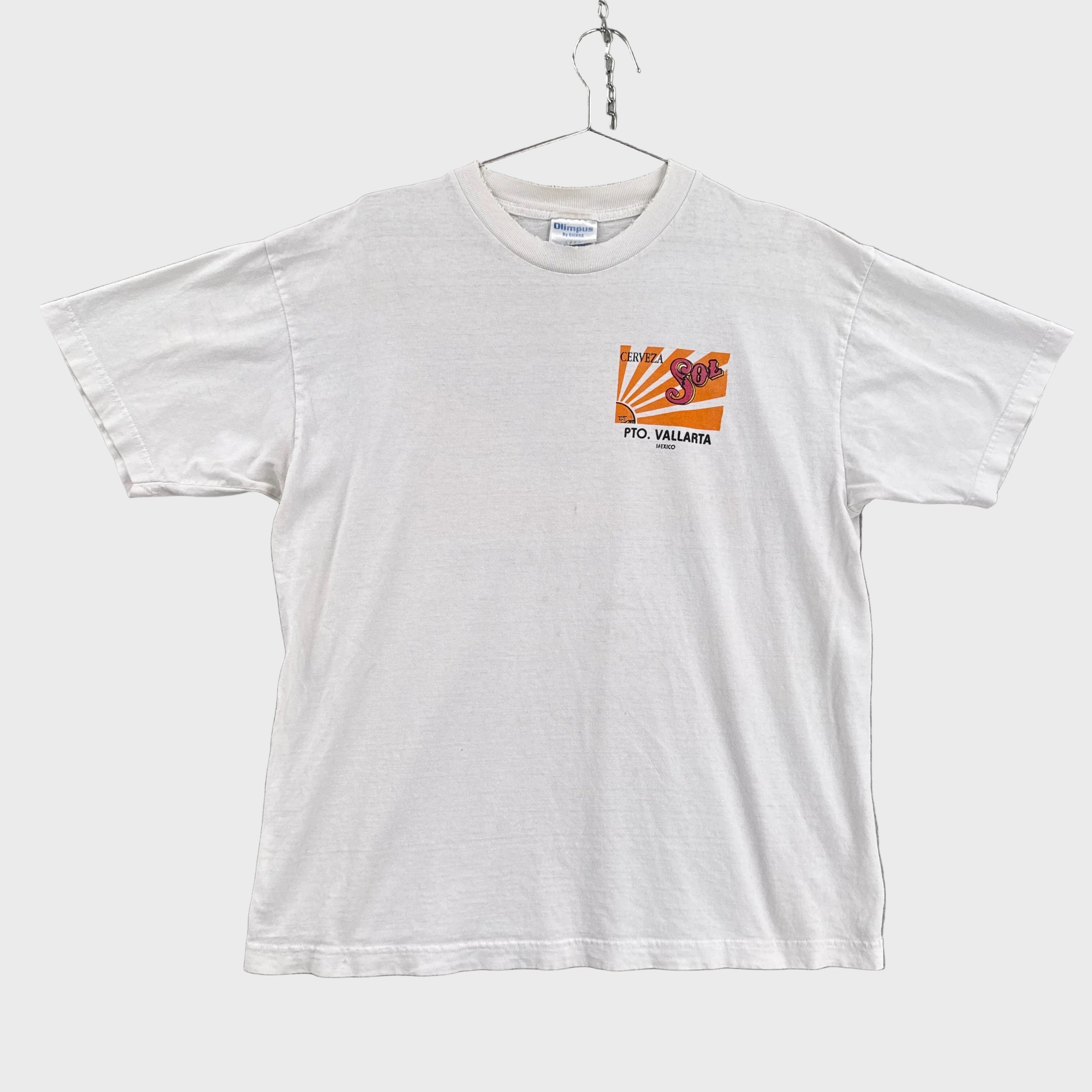 White t-shirt with a small chest logo on a gray background