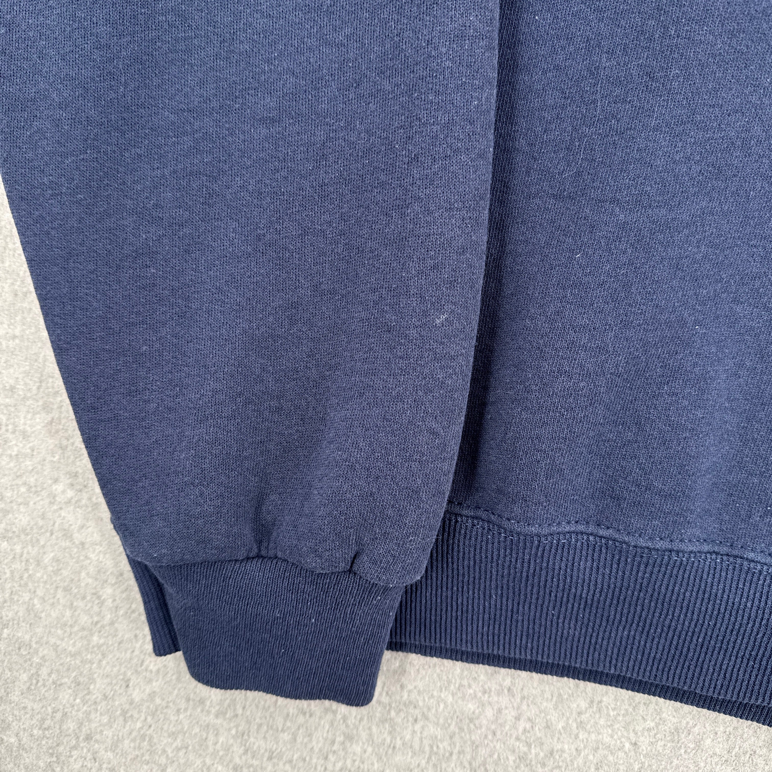 Close-up of a blue fabric texture on a light gray background. small spot on sleeve